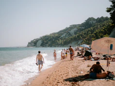 A group of people on a beach near the water
