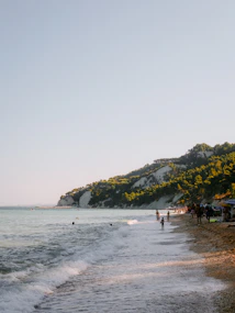 A group of people standing on top of a sandy beach