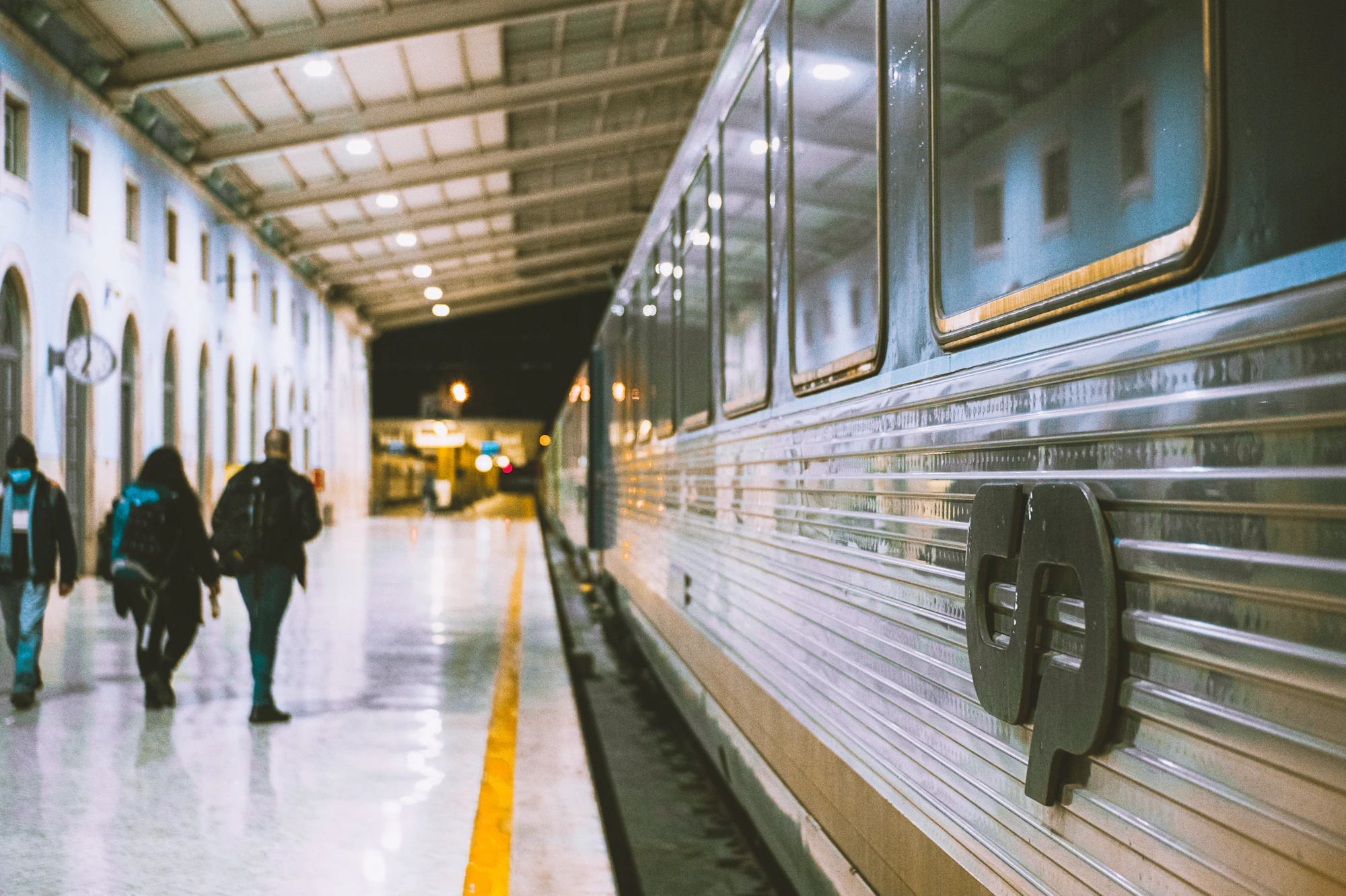 A group of people walking next to a train