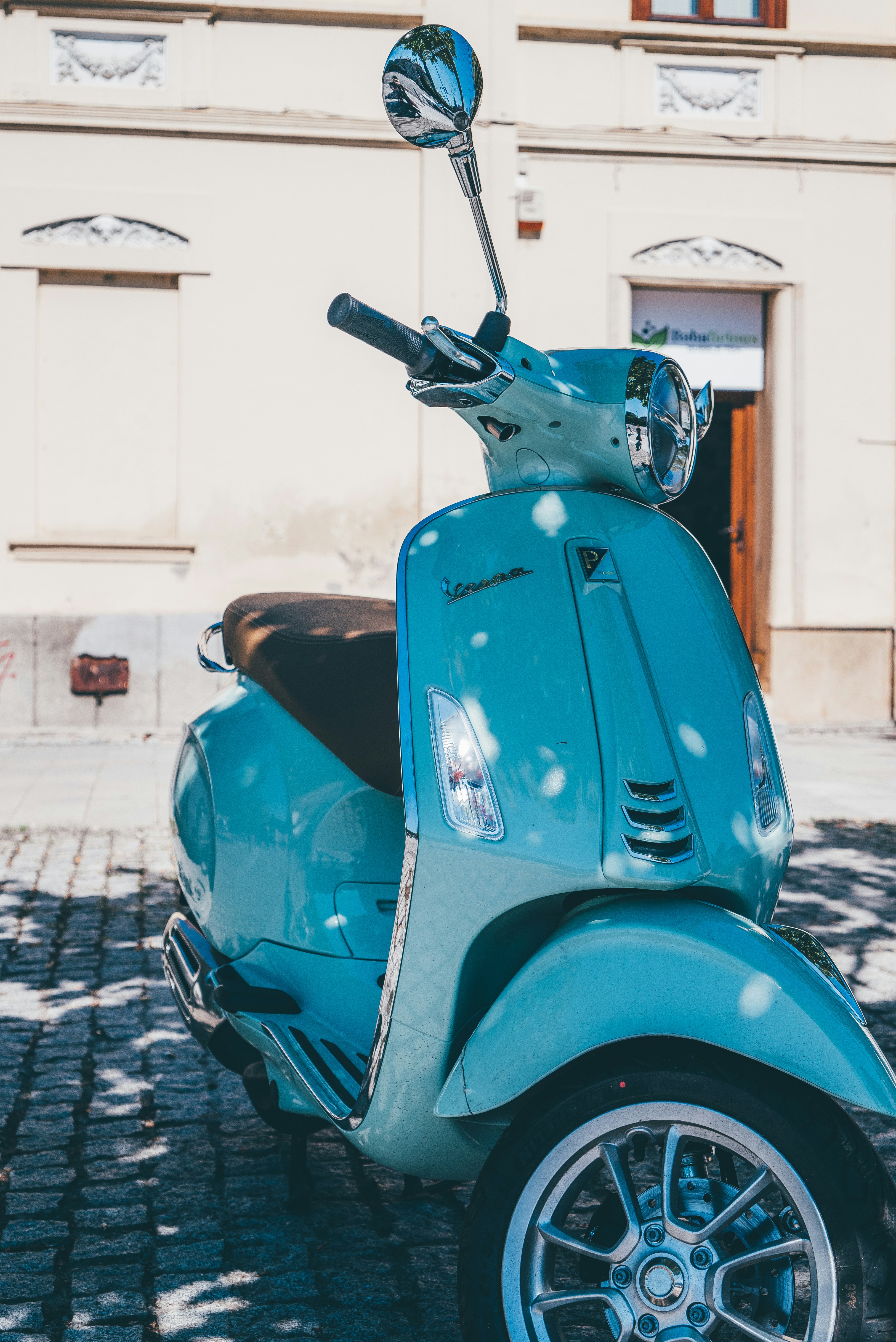 A blue scooter parked in front of a building