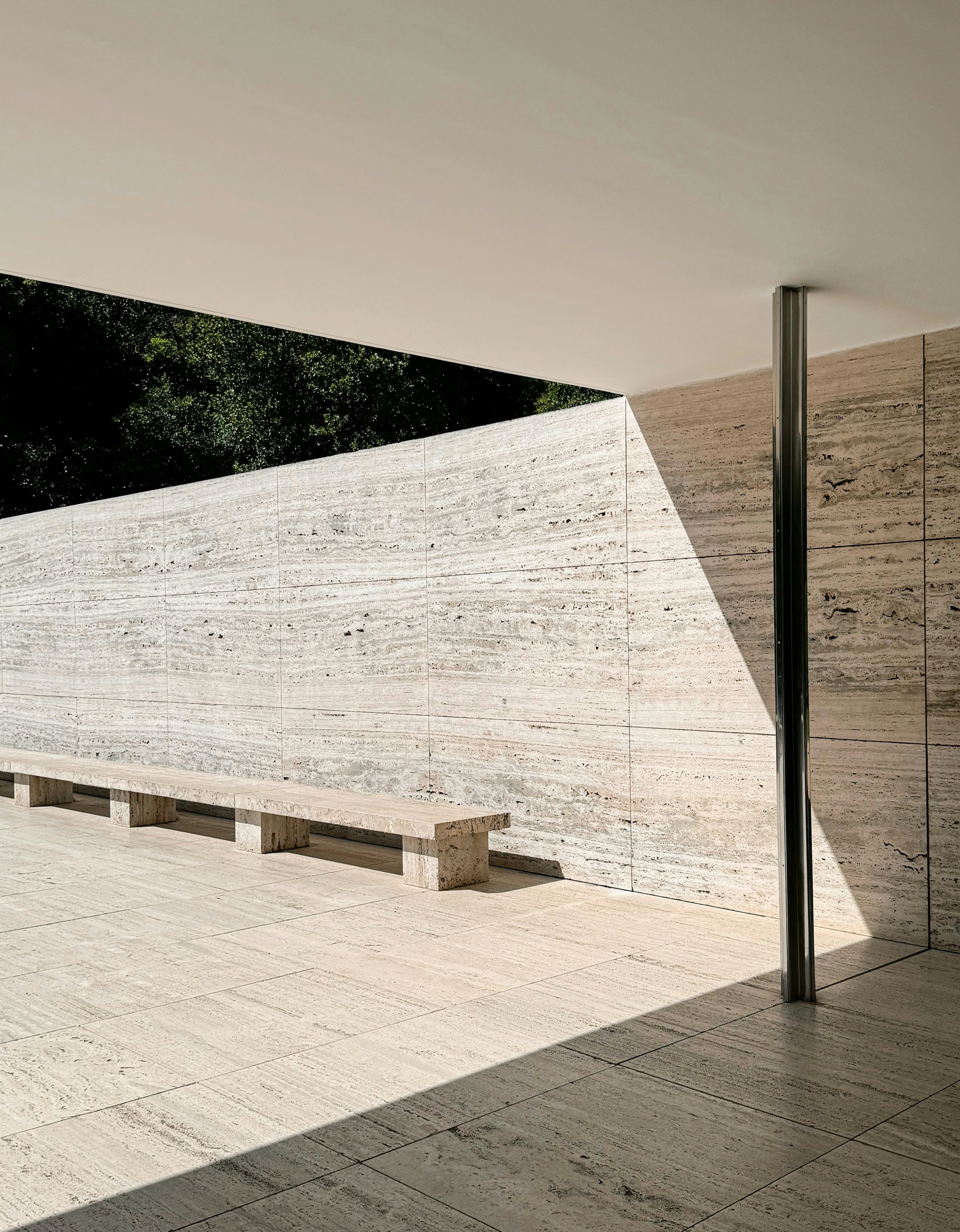 A bench sitting in front of a stone wall