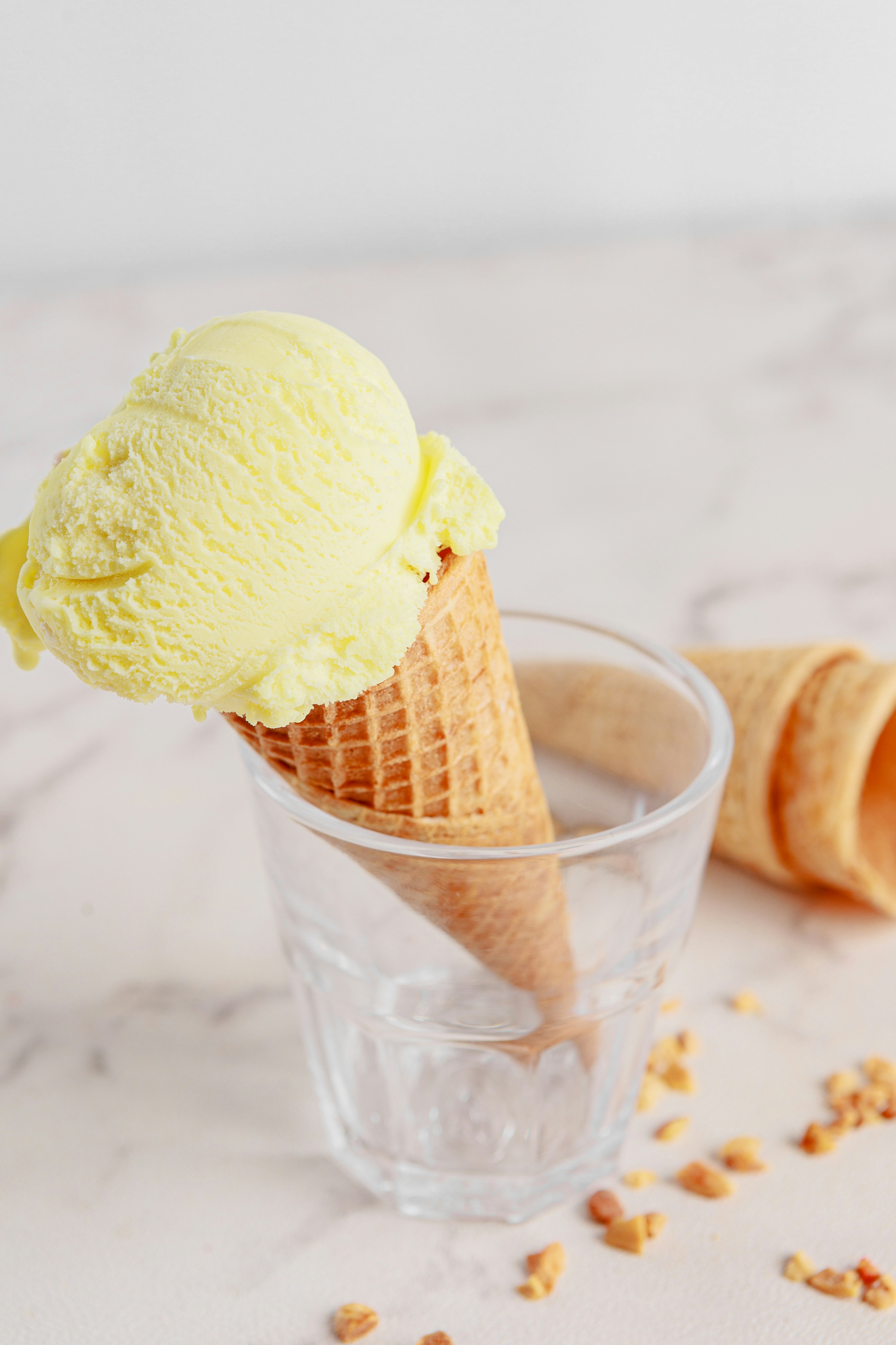 Two scoops of ice cream in a glass on a marble table