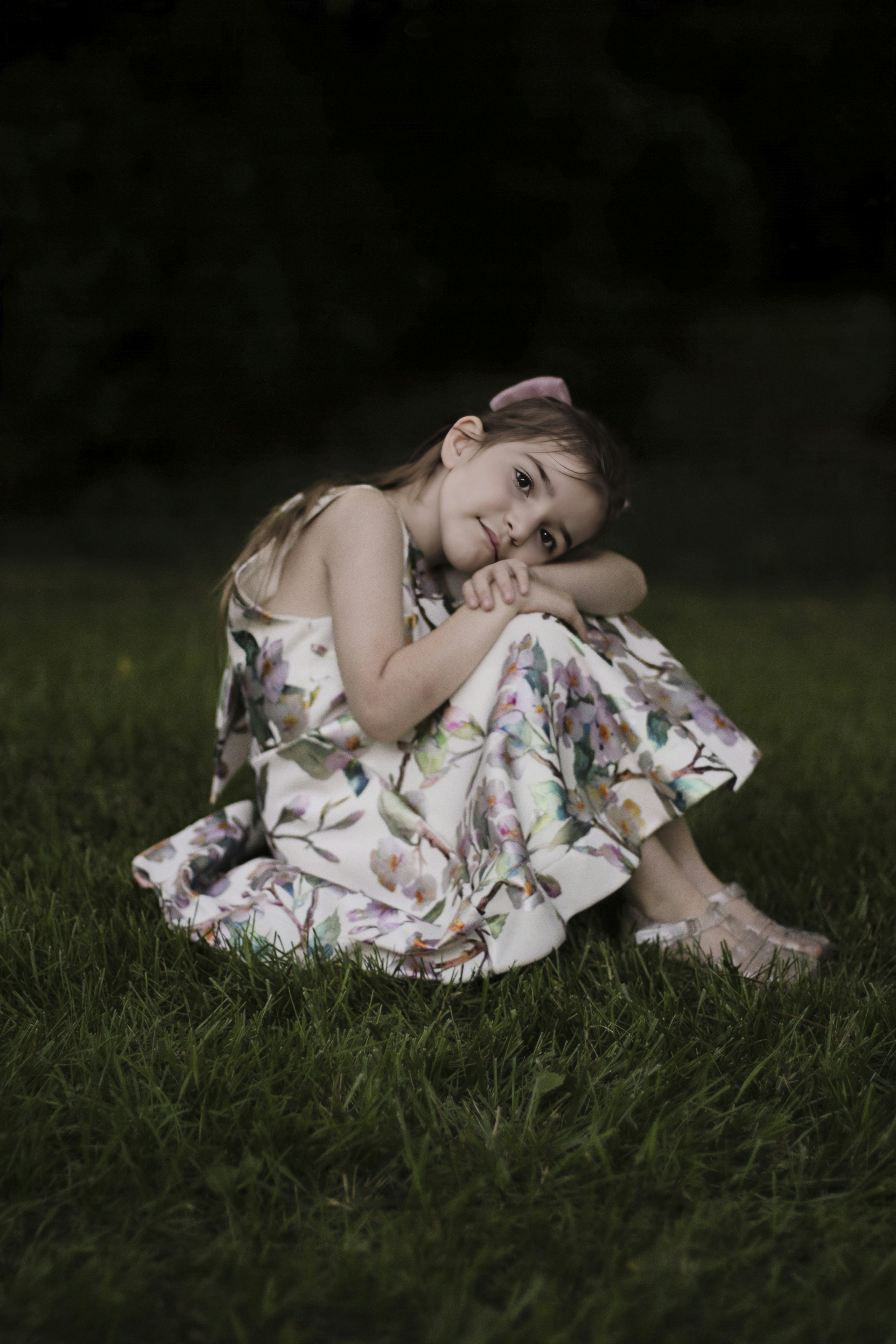 A little girl sitting in the grass in a dress photo – Free Girl Image ...