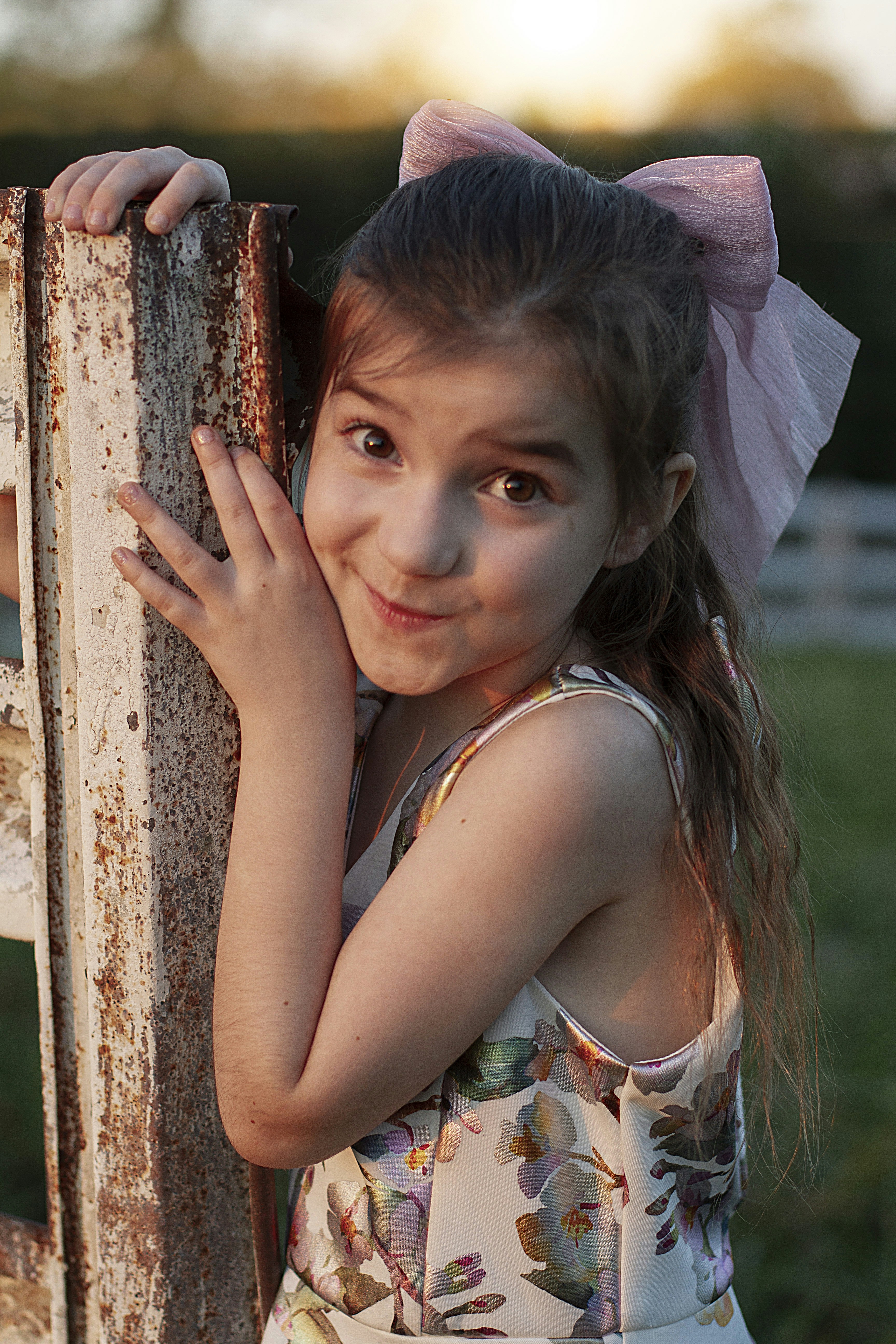 A little girl leaning against a wooden fence