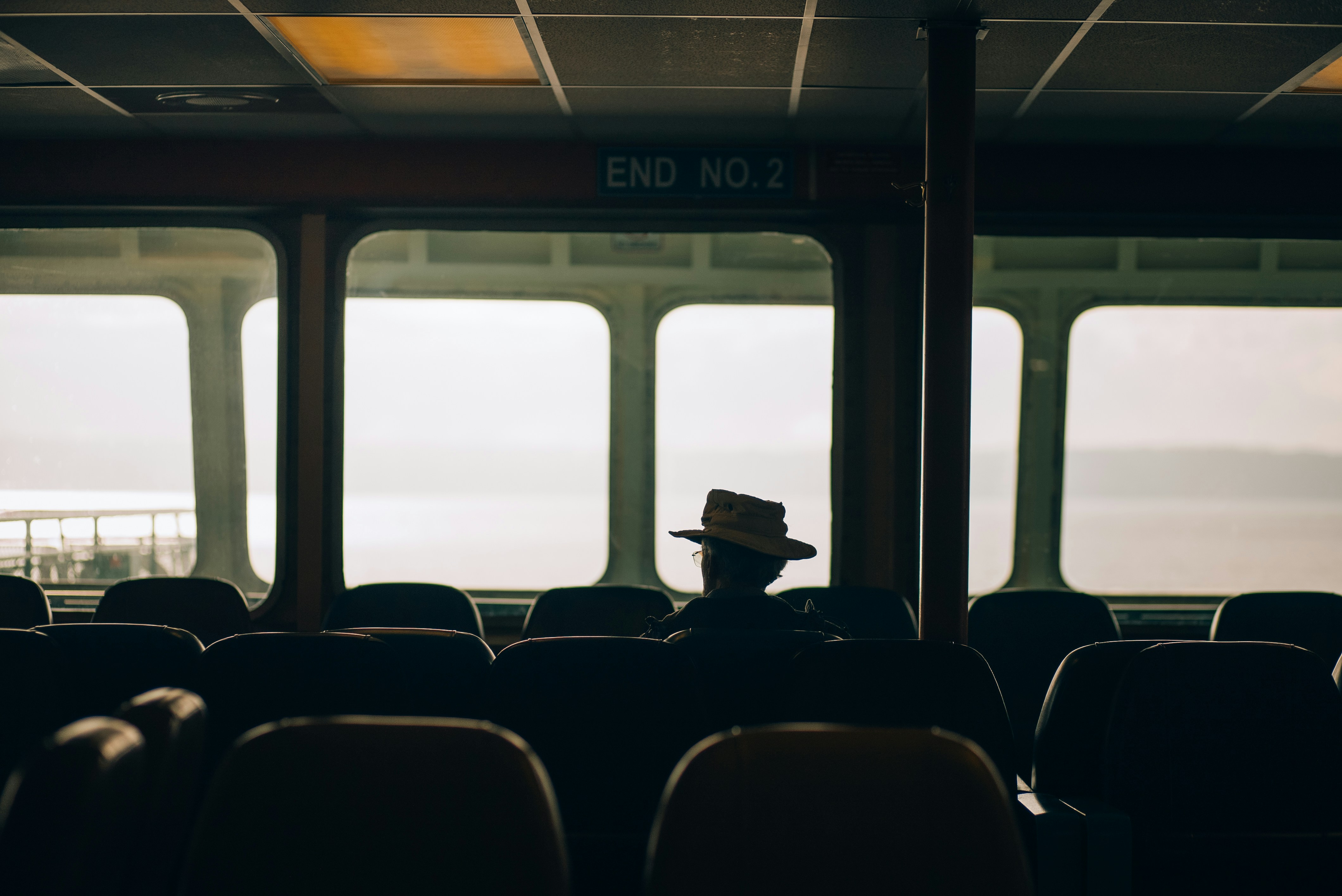 A man in a hat is sitting on a train