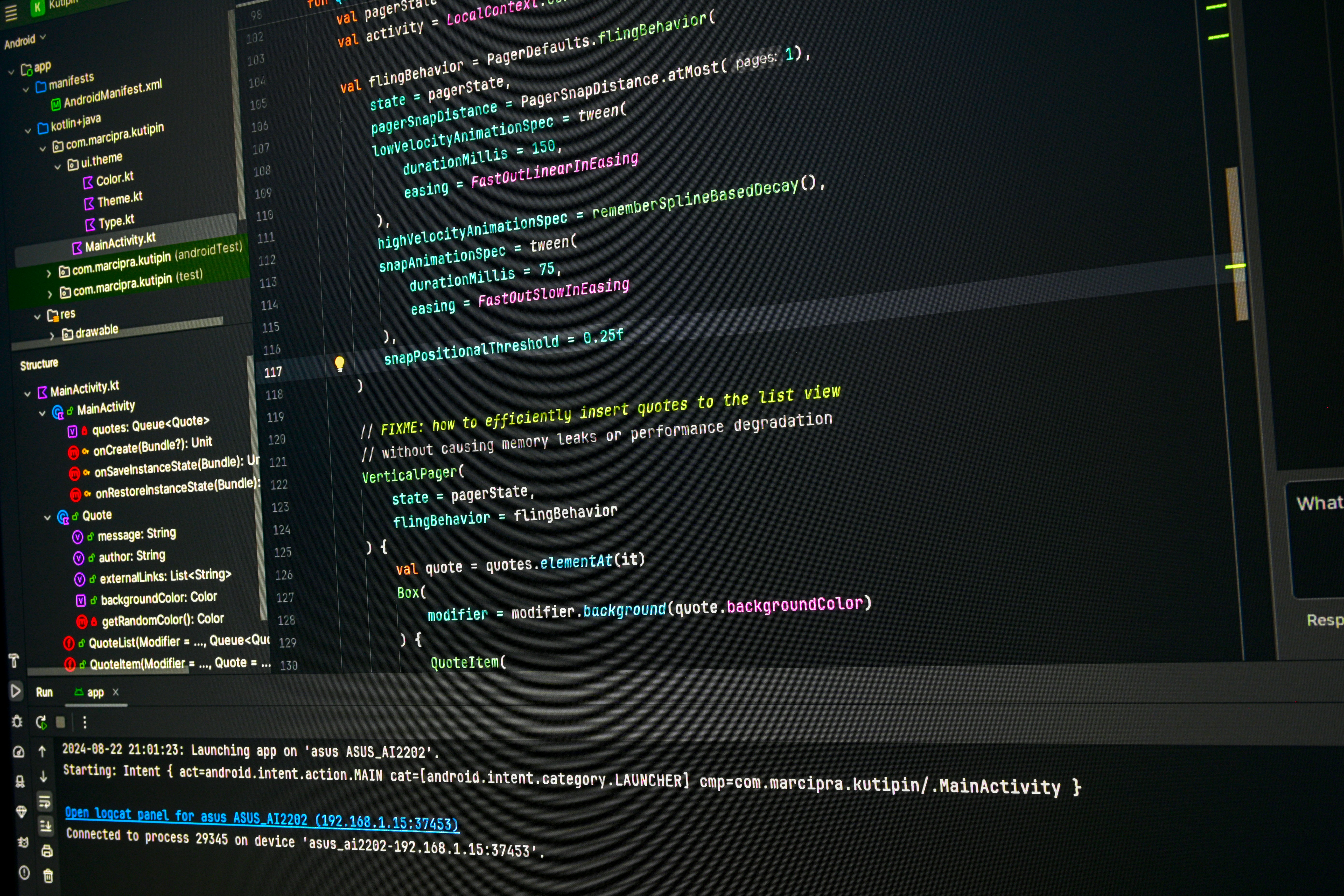 Android smartphone showing app development interface with Kotlin code on laptop screen