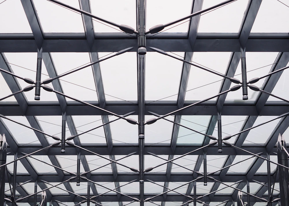 The interior structural steel frame of an industrial building showing long-span trusses and roof purlins
