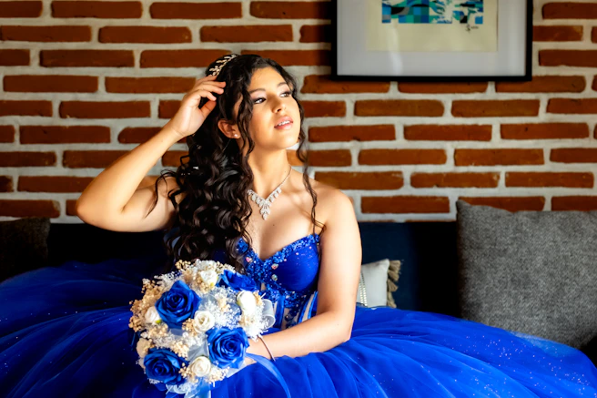 A woman in a blue dress sitting on a couch