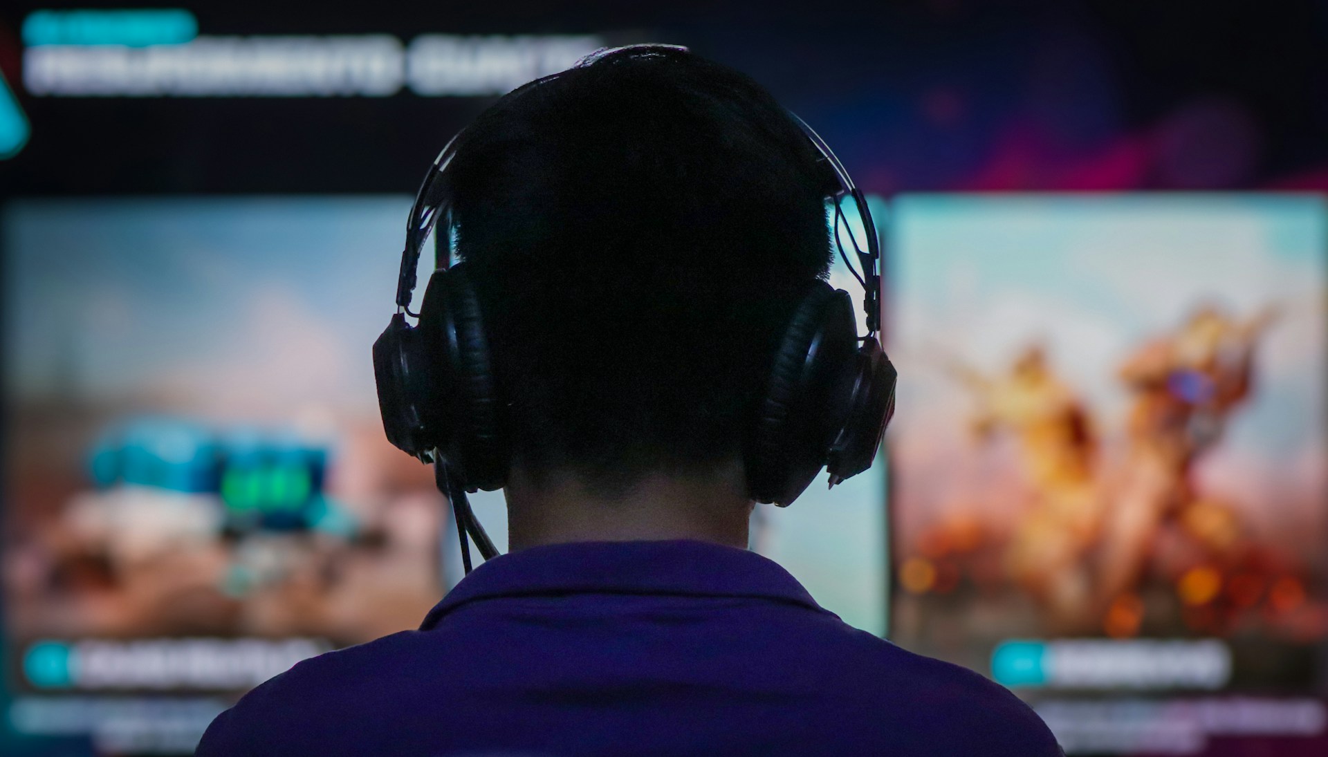 A person wearing headphones in front of a TV