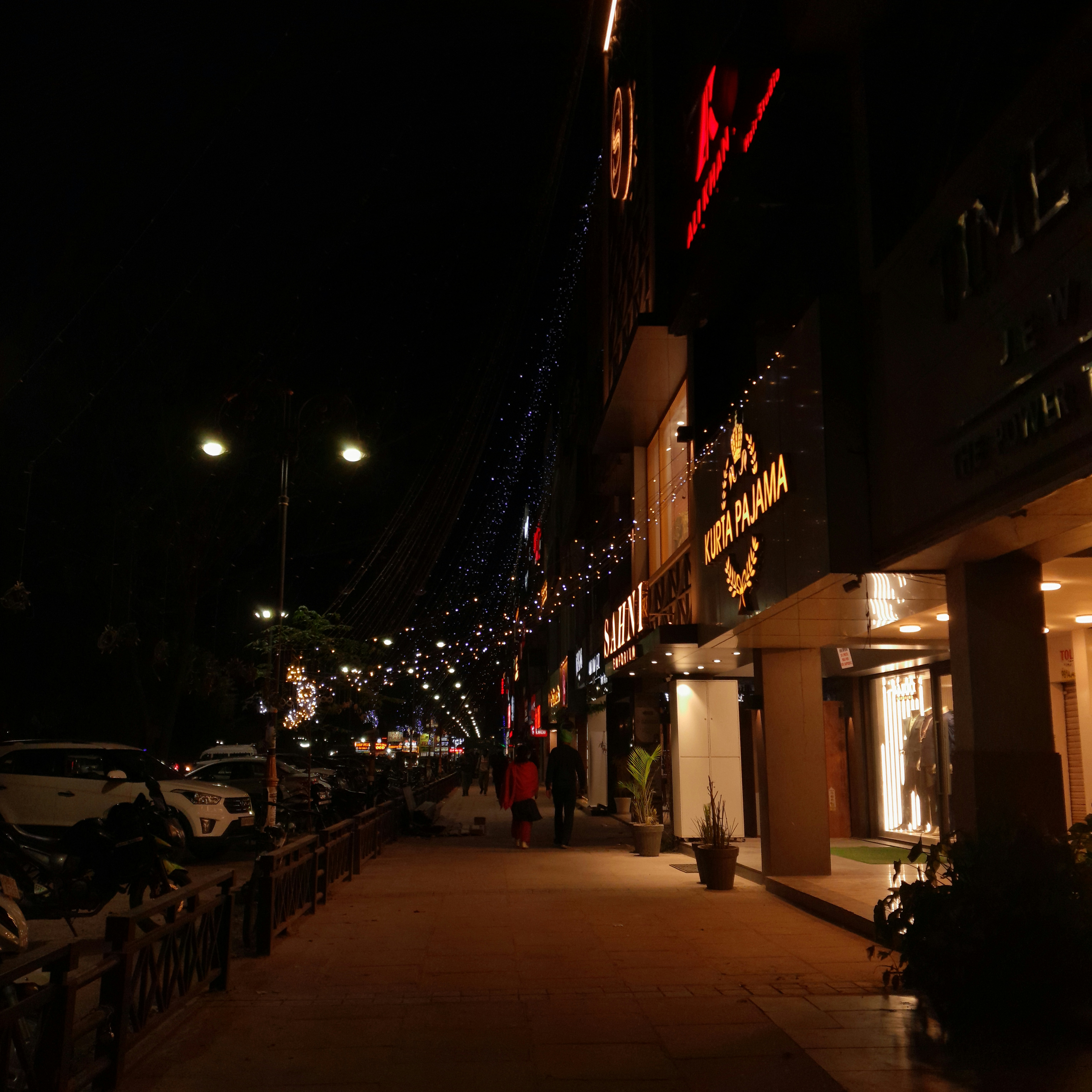 A city street is lit up with christmas lights