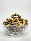 A glass bowl filled with nuts on top of a white table