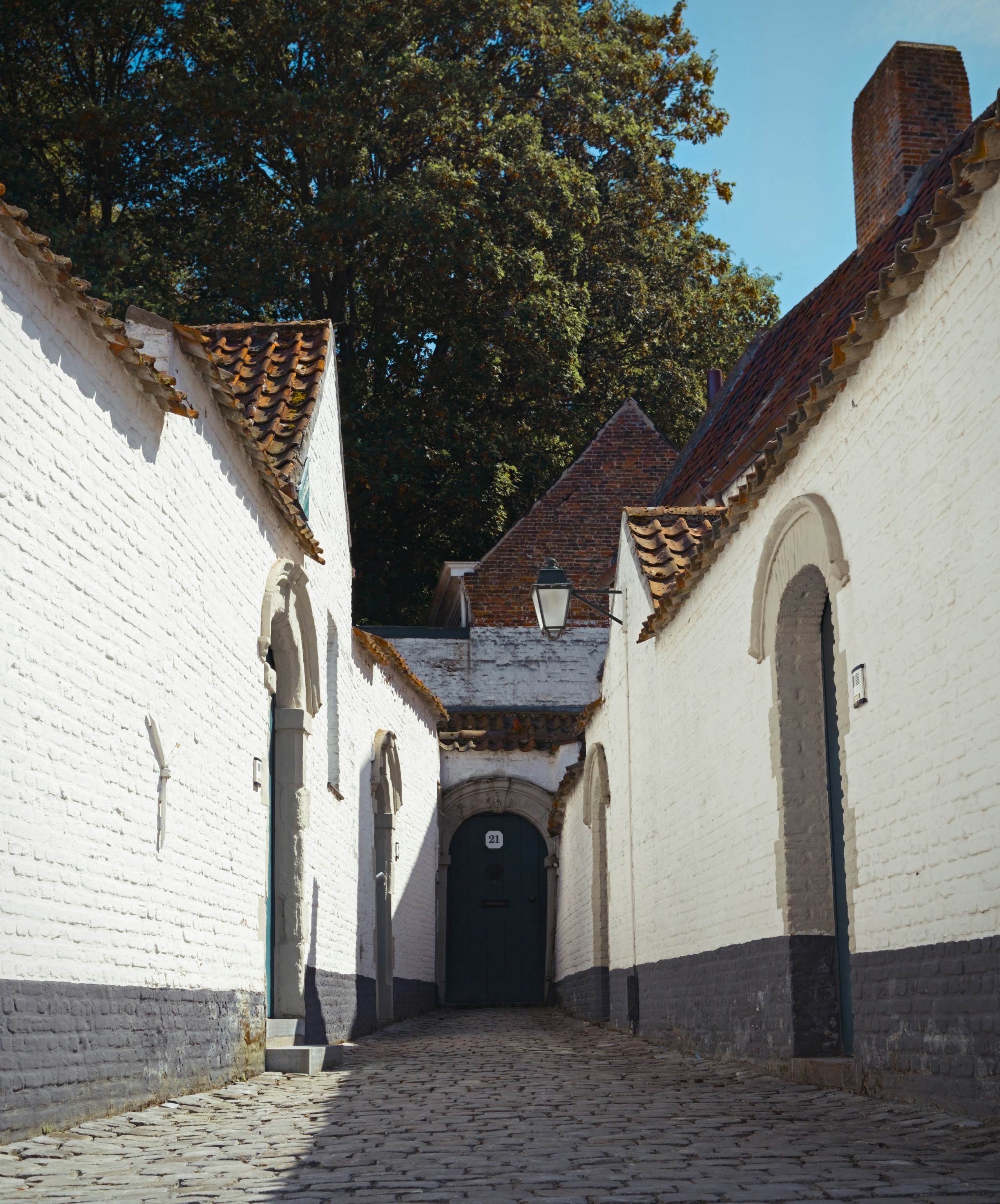 A cobblestone street lined with white brick buildings