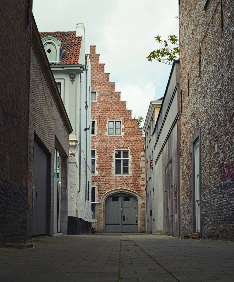 Narrow alley opening toward a clock tower in the distance