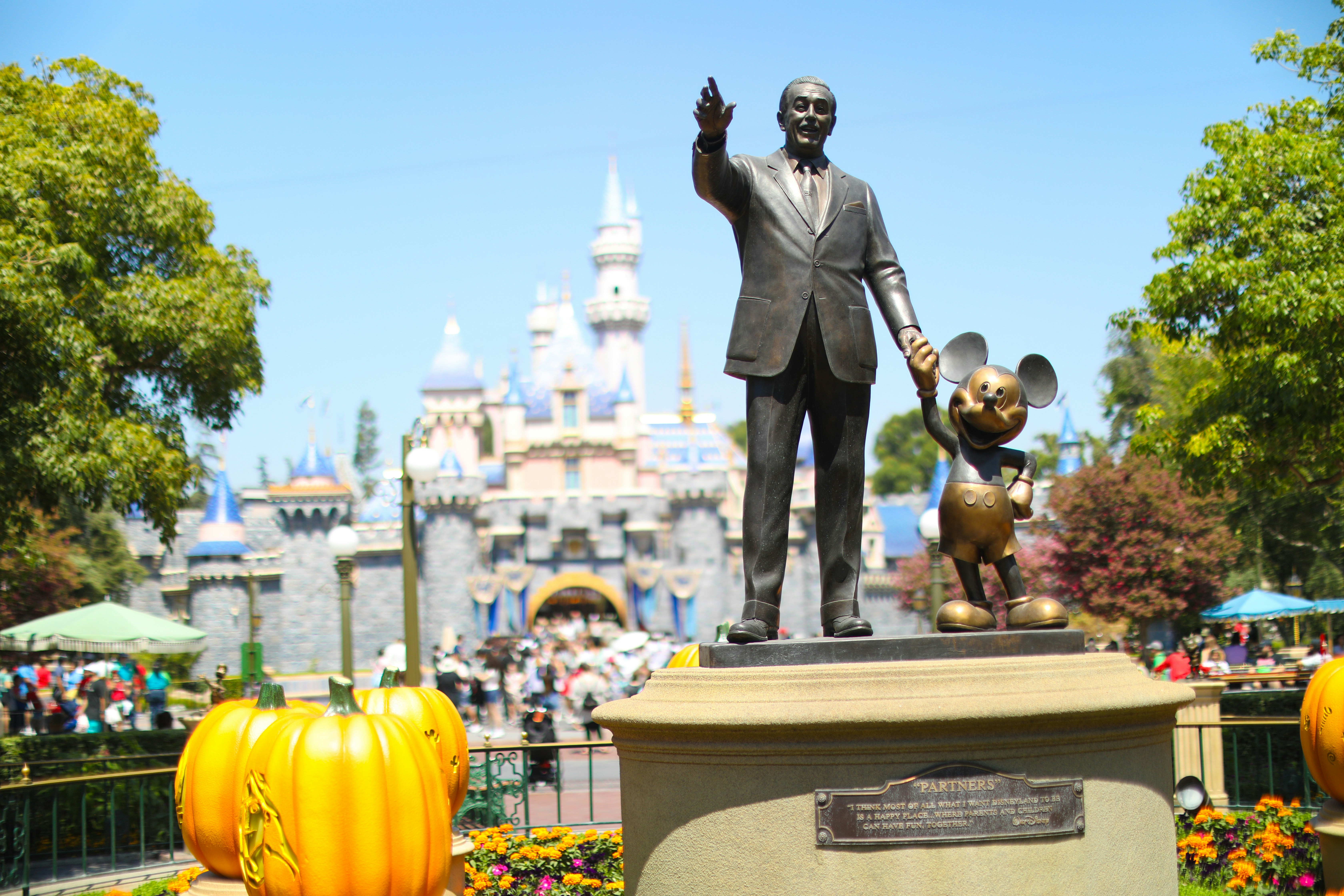 A statue of mickey and mickey mouse in front of a castle