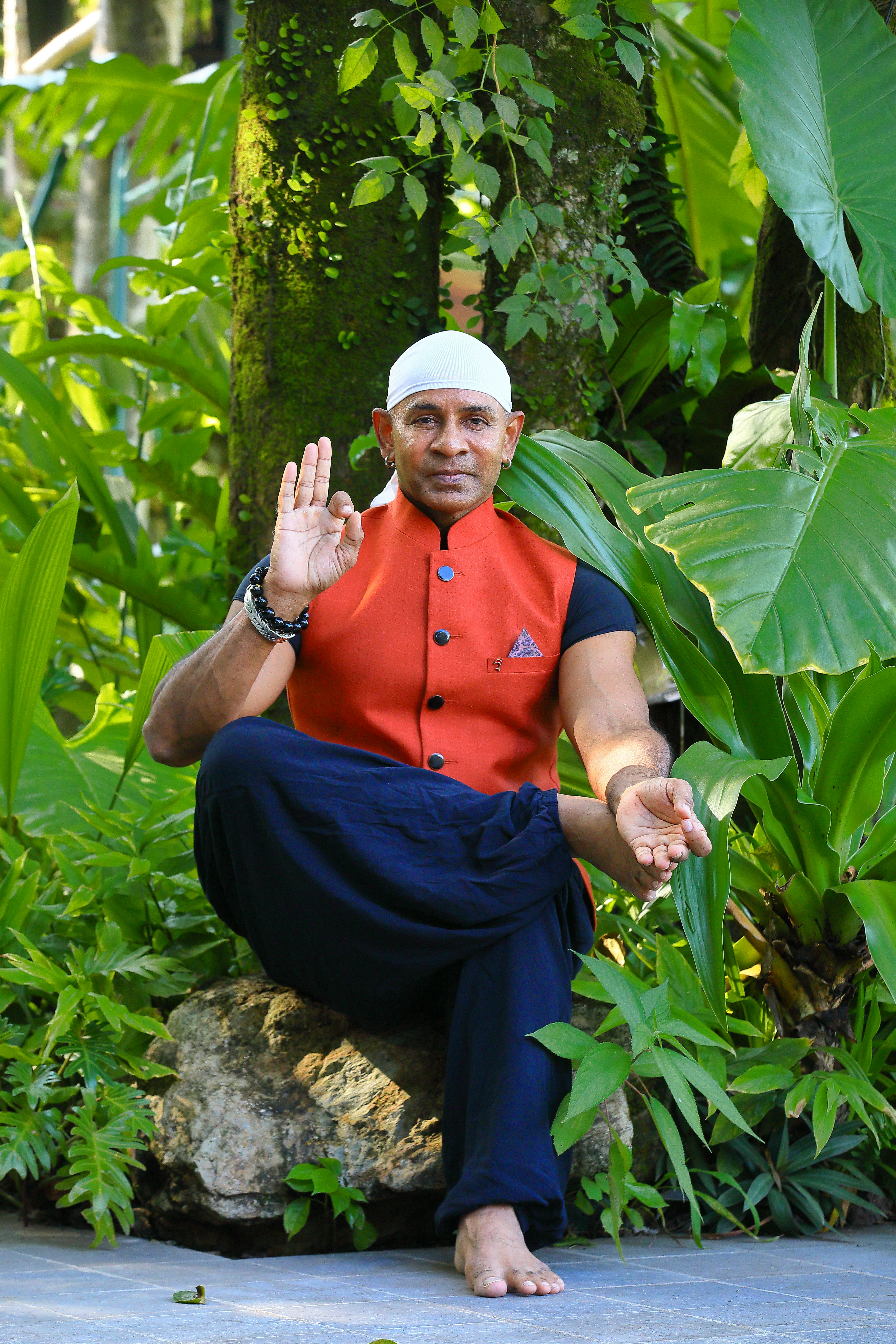 A man sitting on top of a rock in a forest