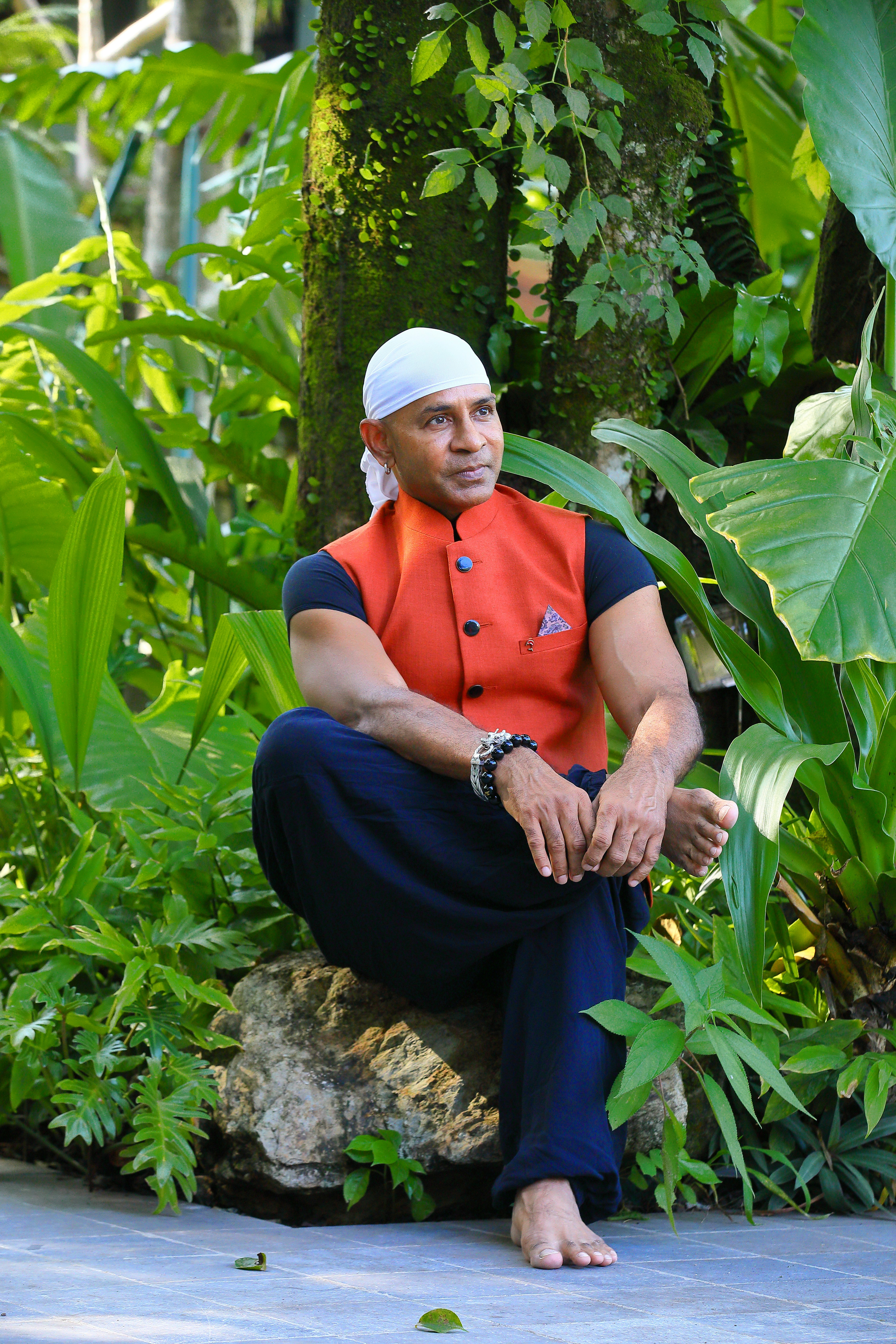 A man sitting on a rock in a garden
