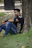 A man sitting under a tree on the grass