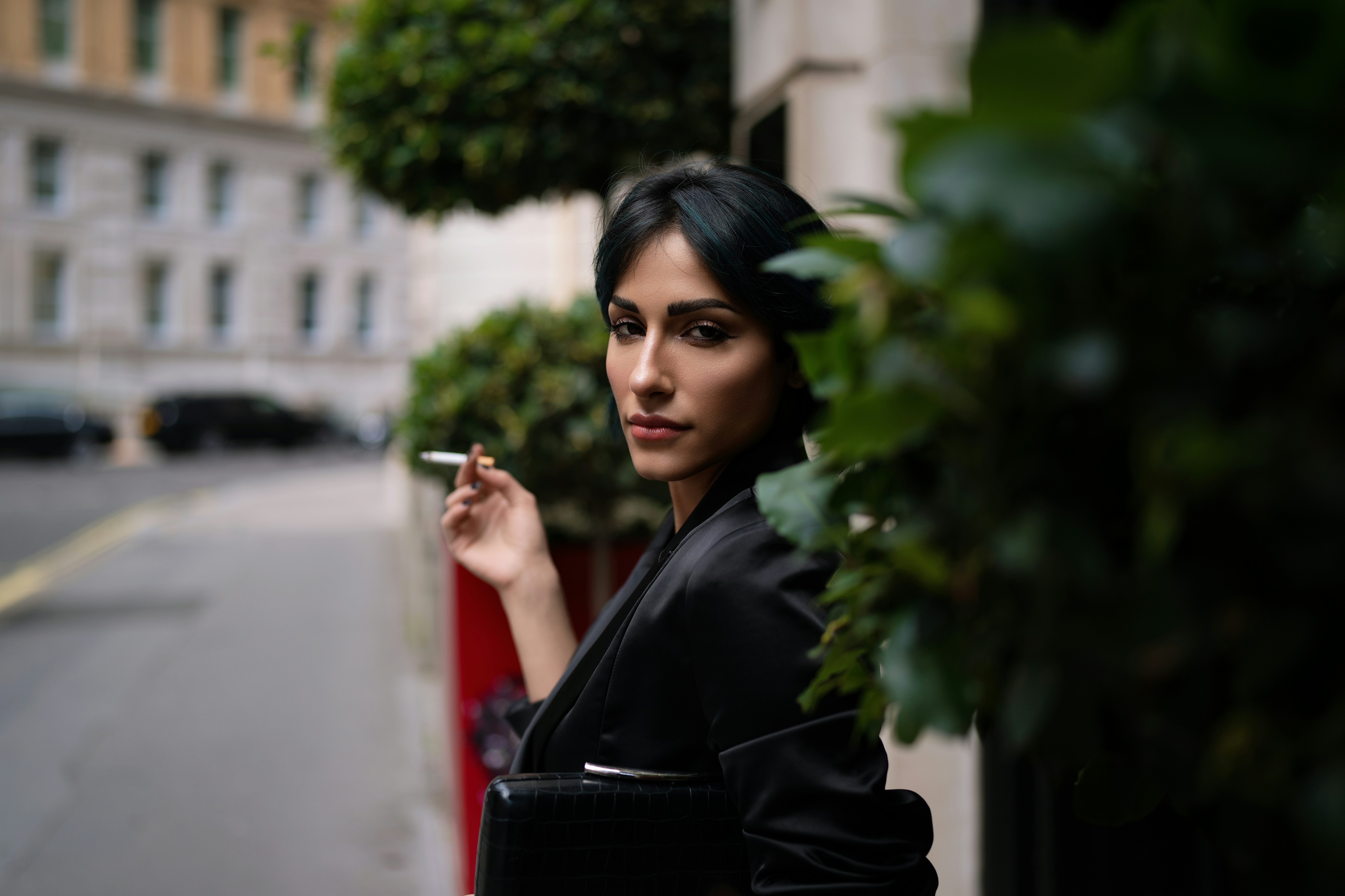 A woman smoking a cigarette on a city street