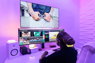 A person sitting at a desk in front of a TV