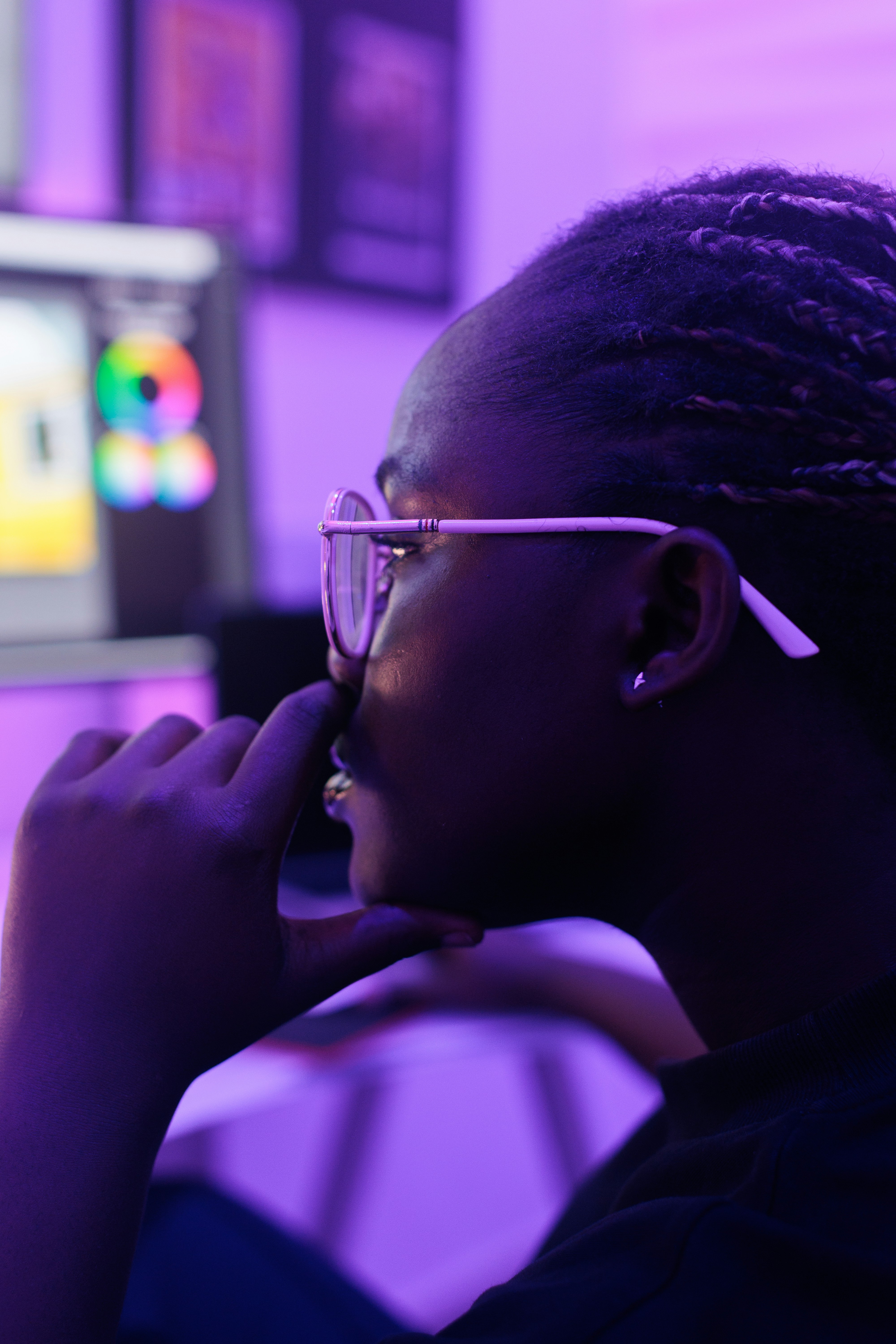 A woman with glasses is looking at a computer screen