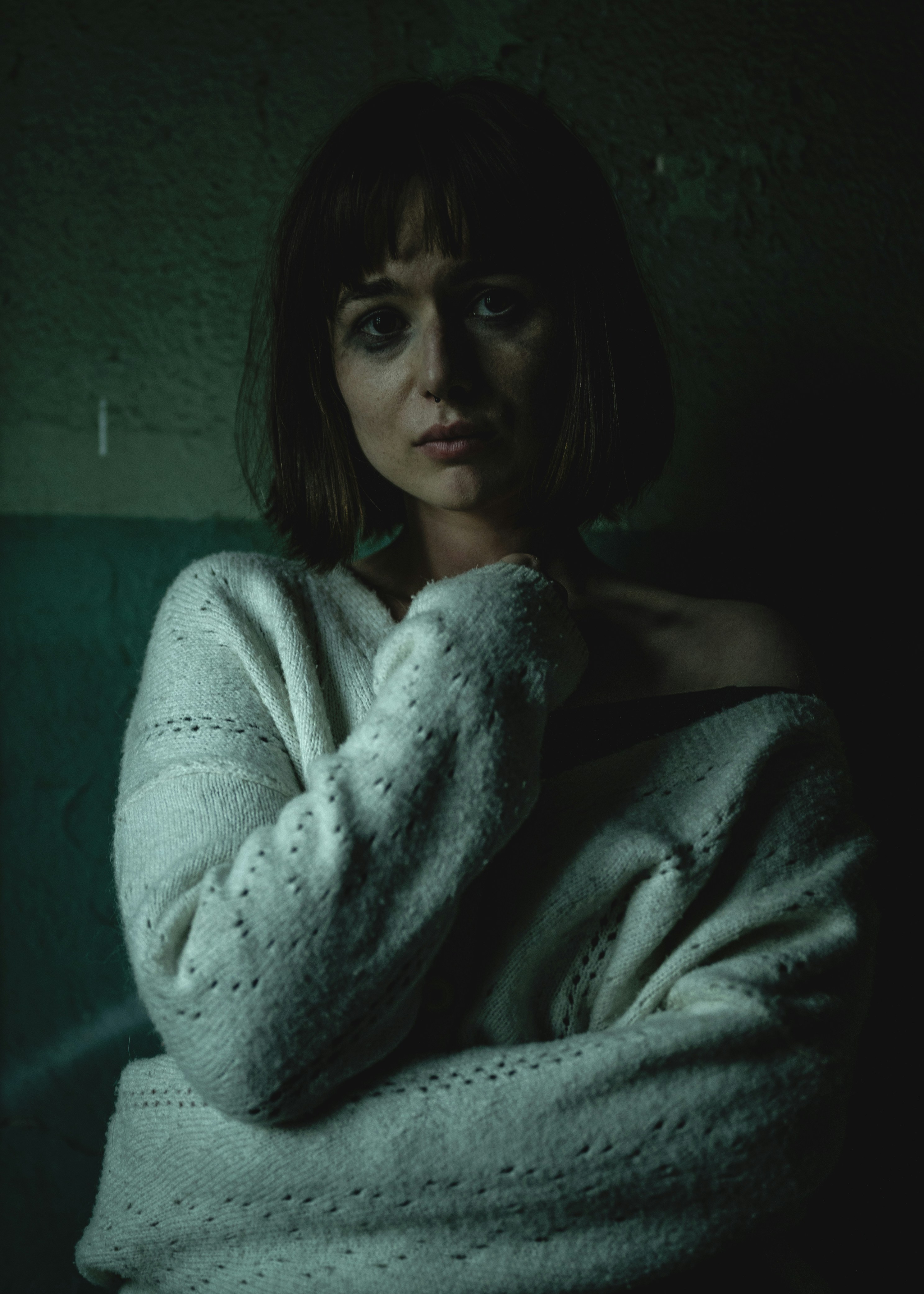 A woman wrapped in a blanket in a dark room