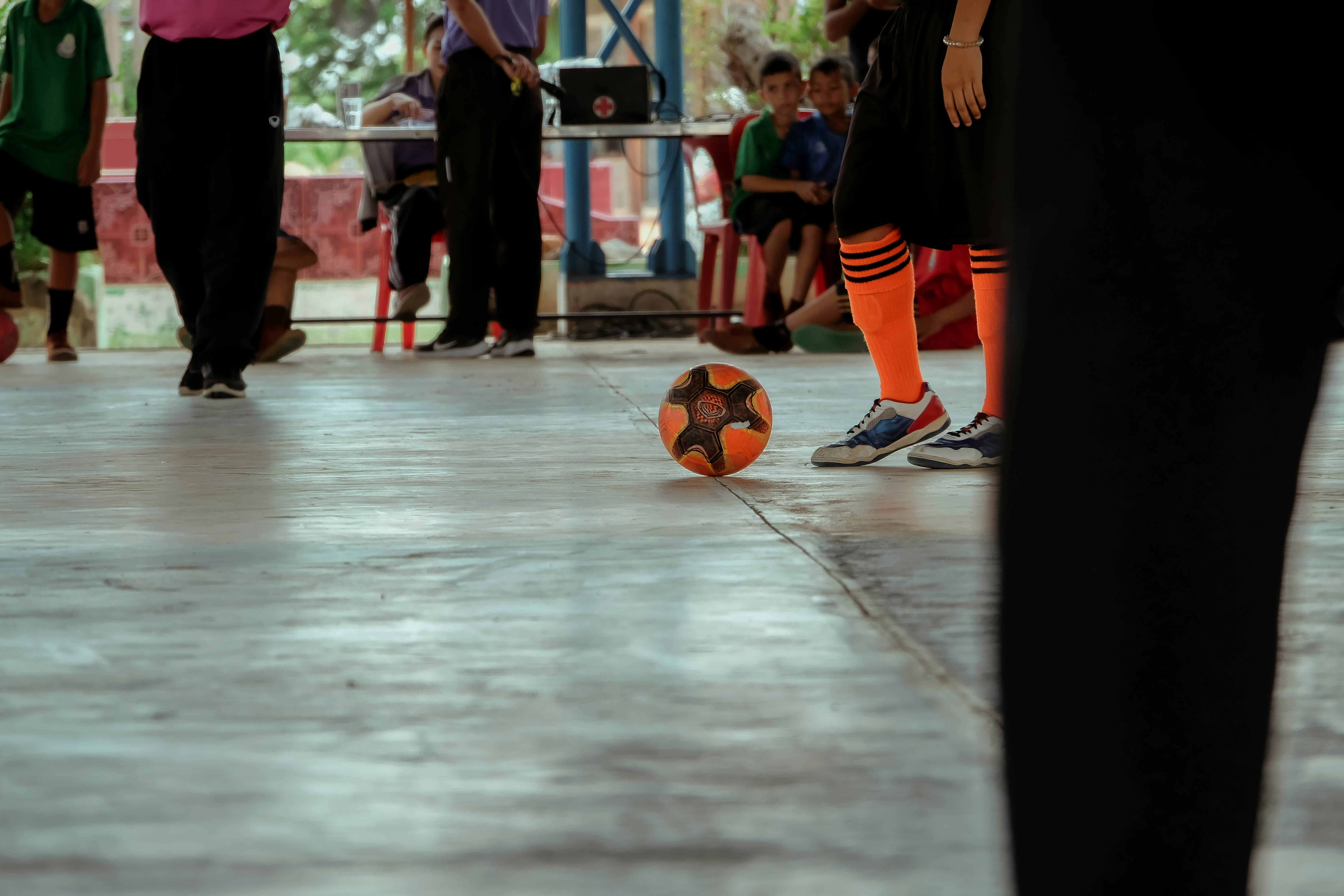 A group of people standing around a soccer ball