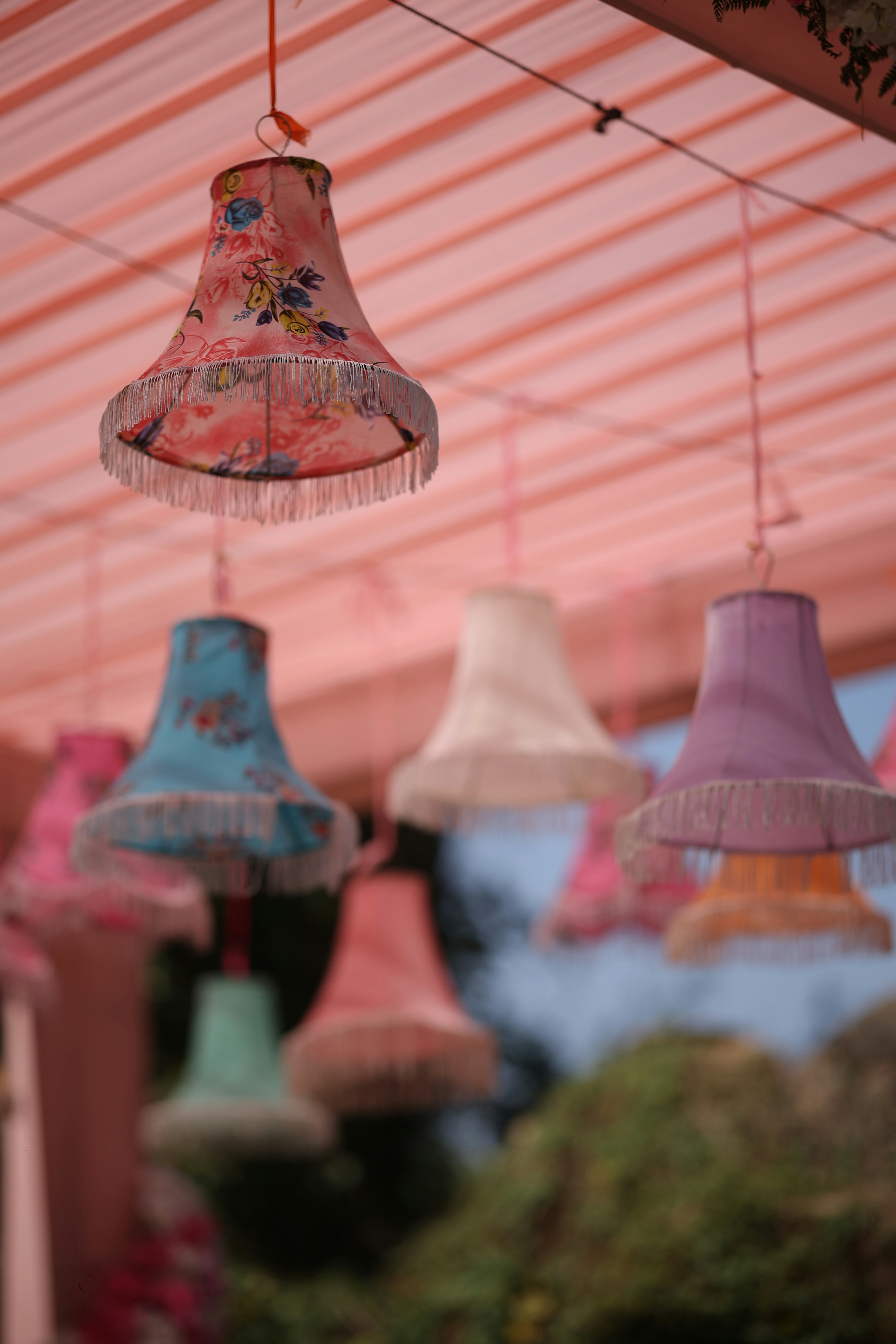 A bunch of different colored lights hanging from a ceiling