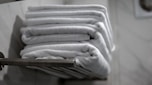 A stack of folded towels sitting on a towel rack