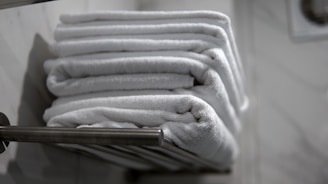 A stack of folded towels sitting on a towel rack