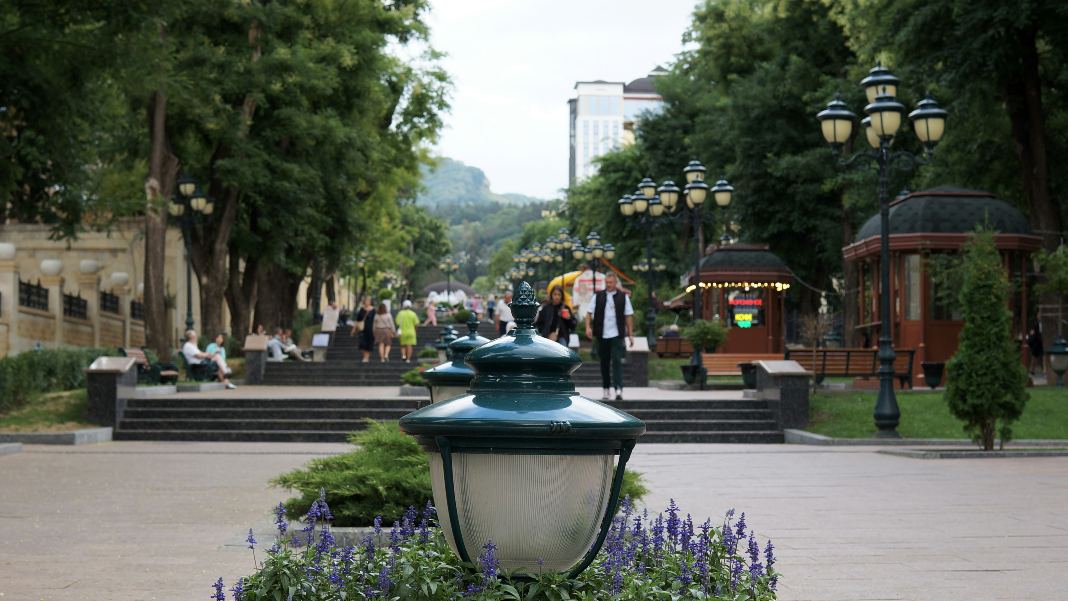 A green and white lamp post sitting in the middle of a park