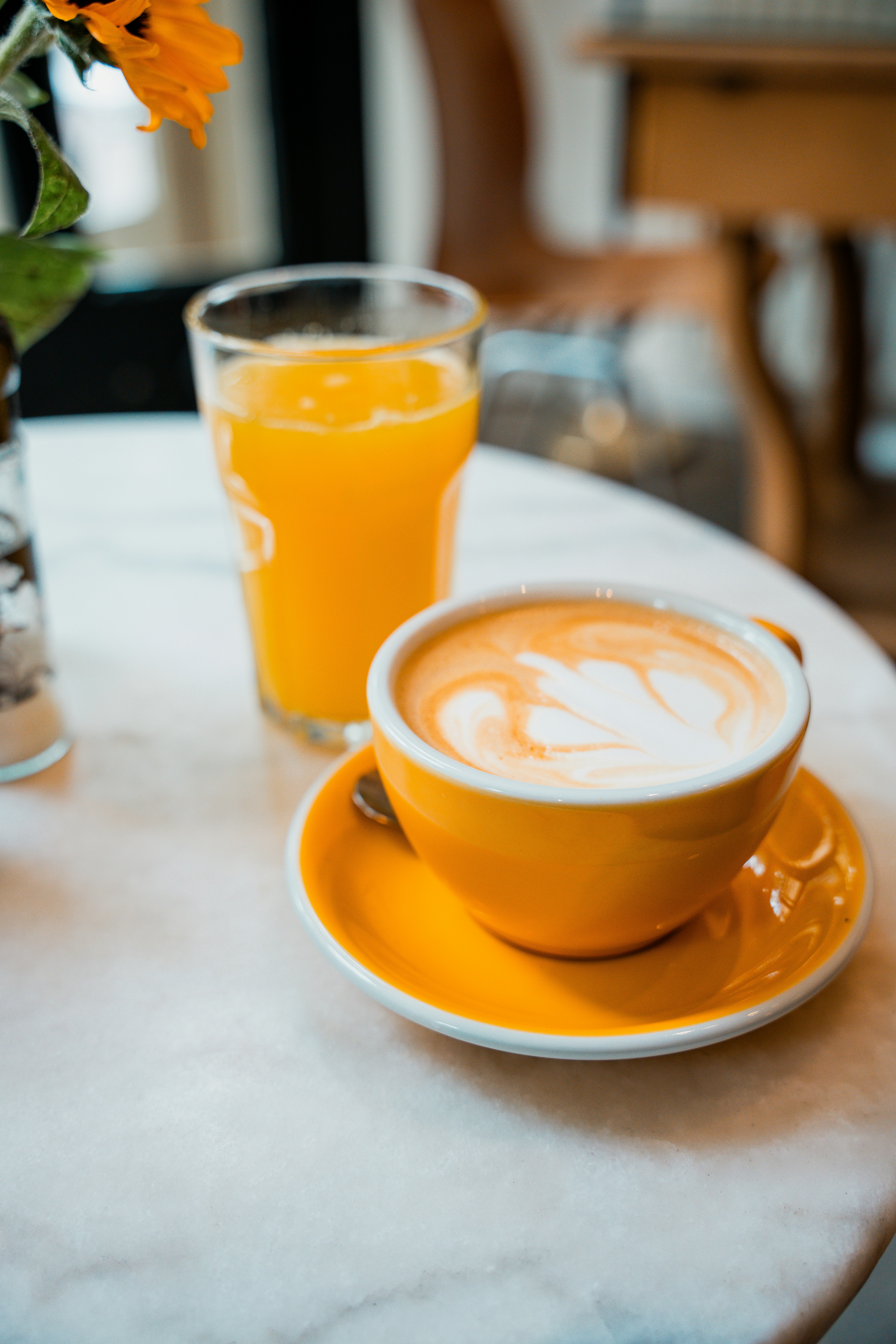 A cup of coffee and a vase of flowers on a table