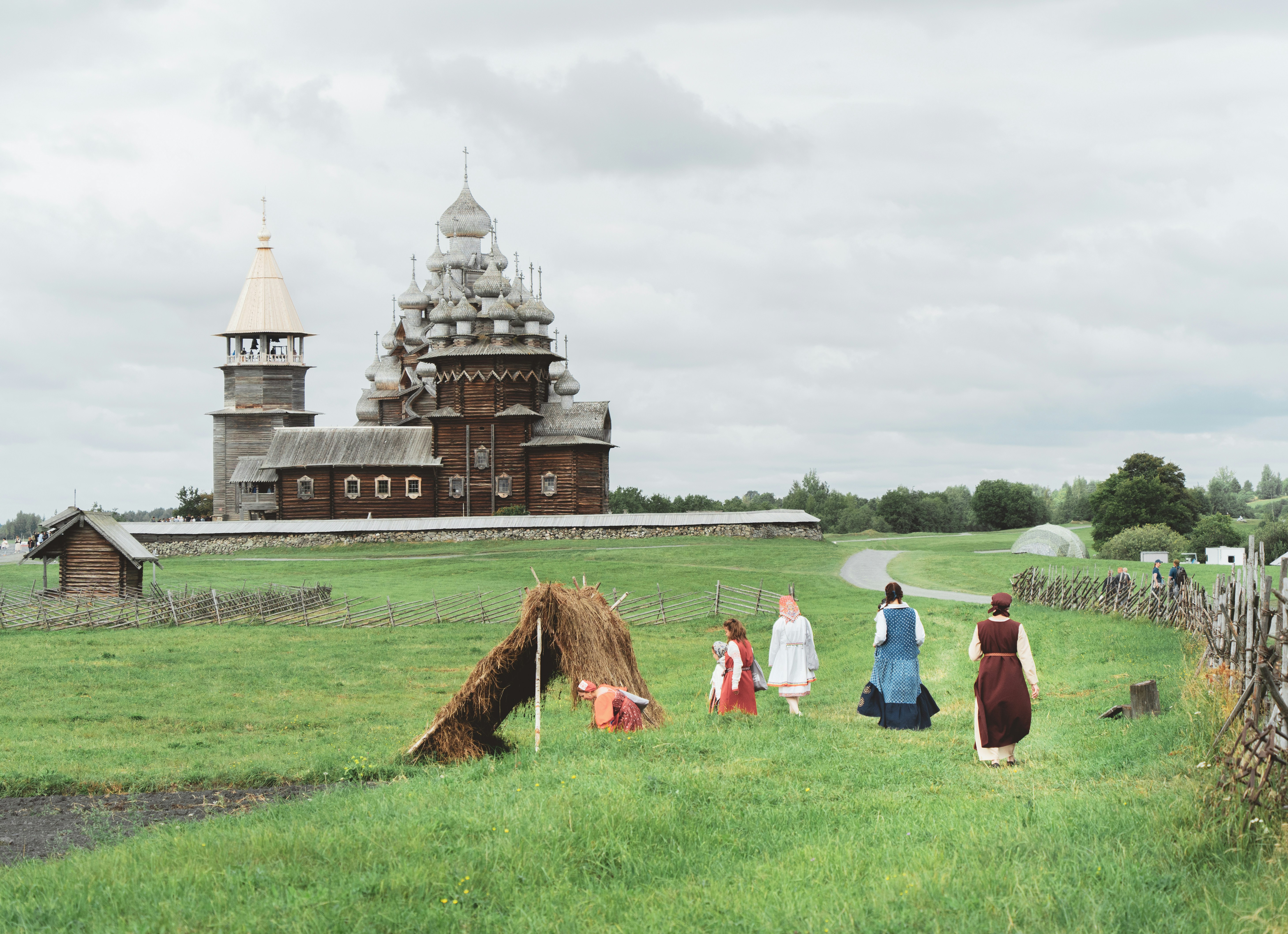 A group of people walking across a lush green field