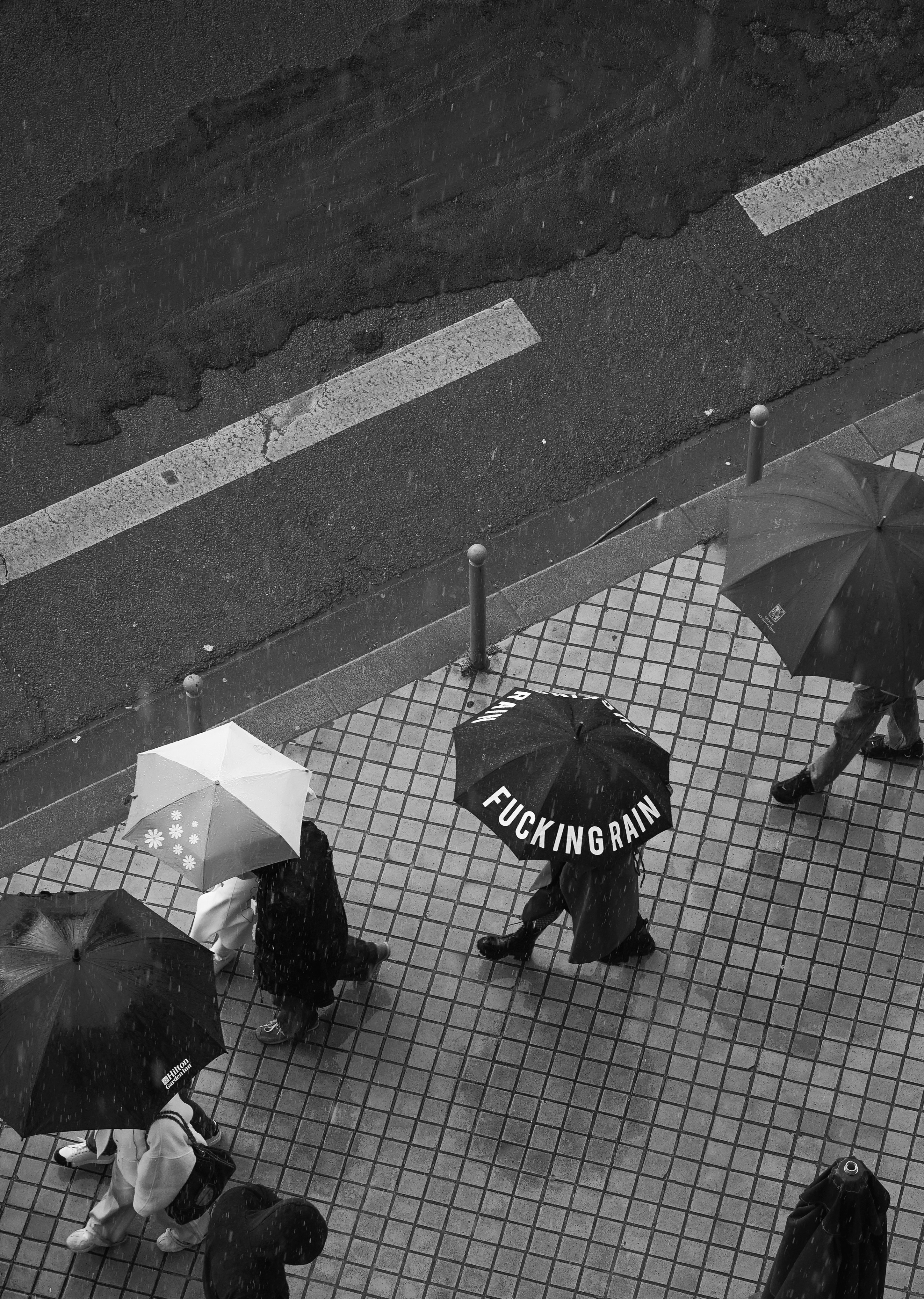 A group of people walking down a street holding umbrellas