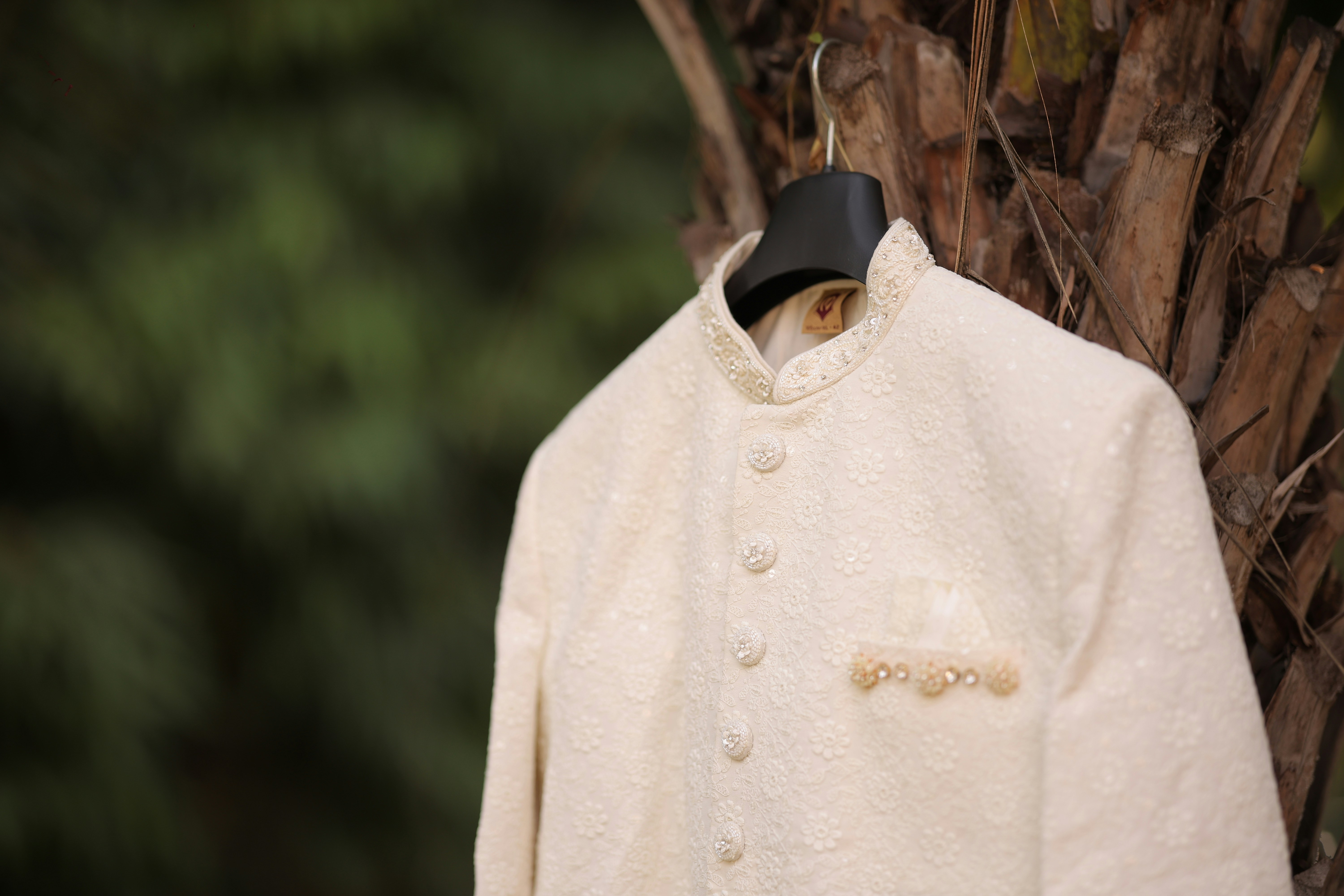A close-up of the groom's sherwani, highlighting the exquisite embroidery and rich fabric, symbolizing elegance and tradition