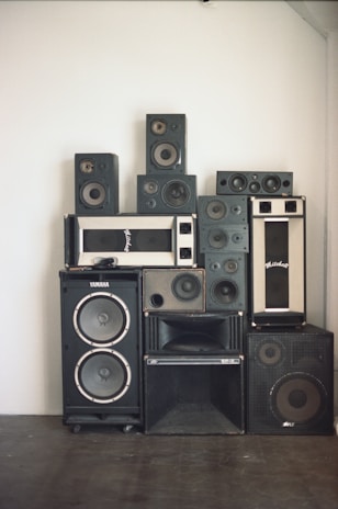 A bunch of speakers are stacked on top of each other