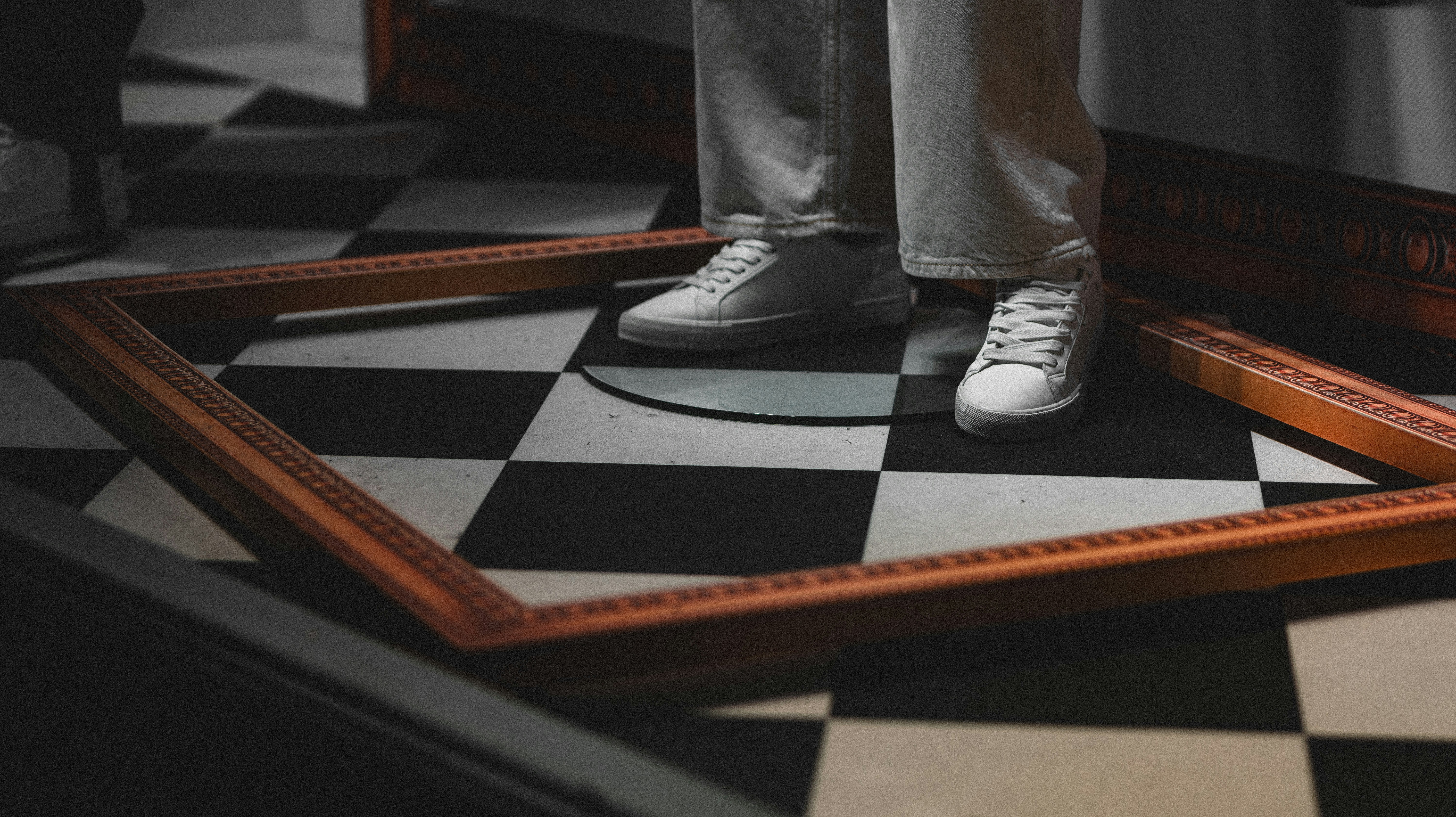 A person standing on a black and white checkered floor