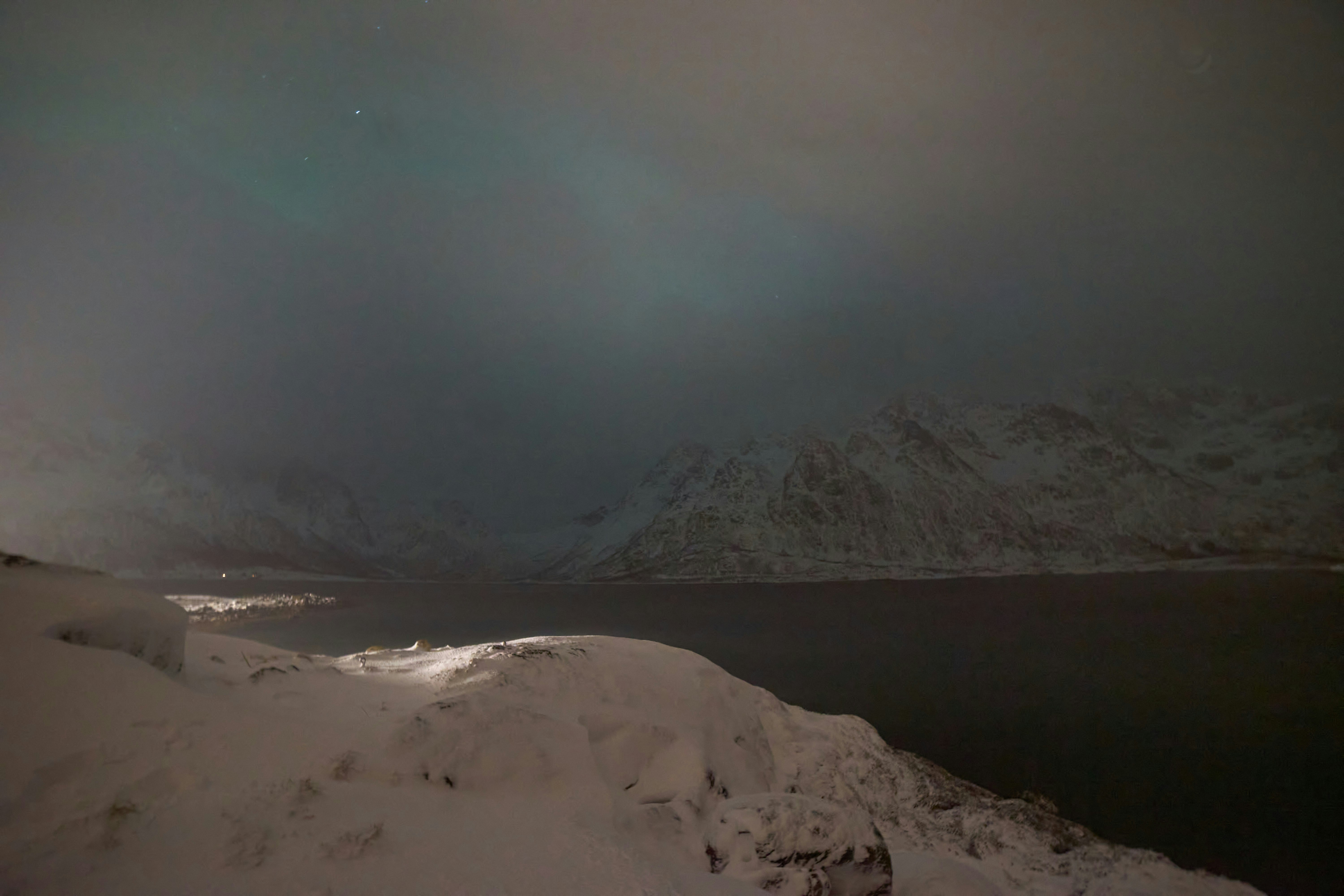 A snowboarder is going down a snowy hill