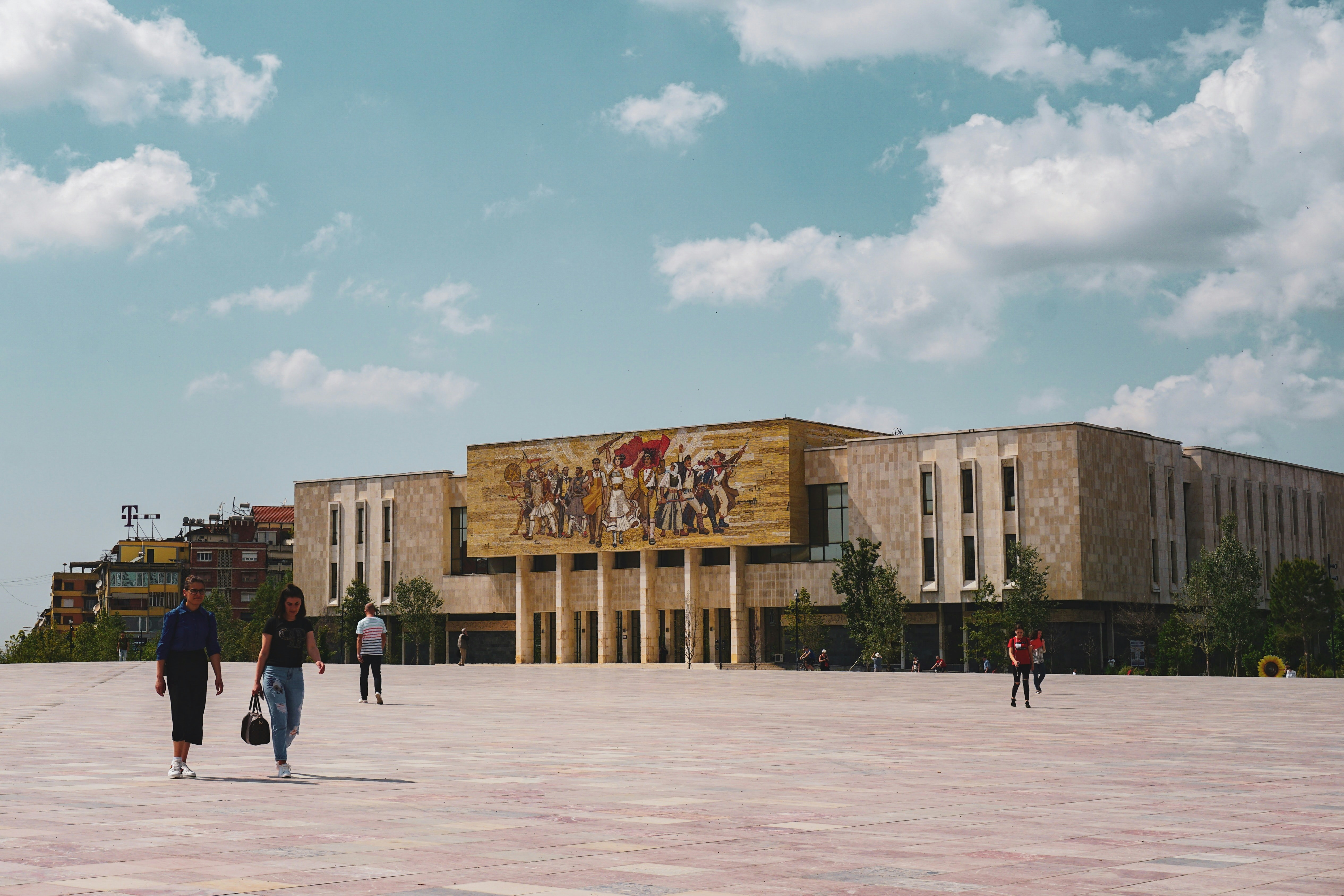 A group of people walking in front of a building
