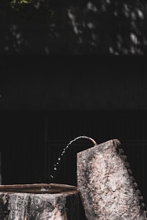 A water fountain with a wooden bucket on top of it