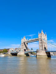 A large bridge spanning over a river next to a tall building