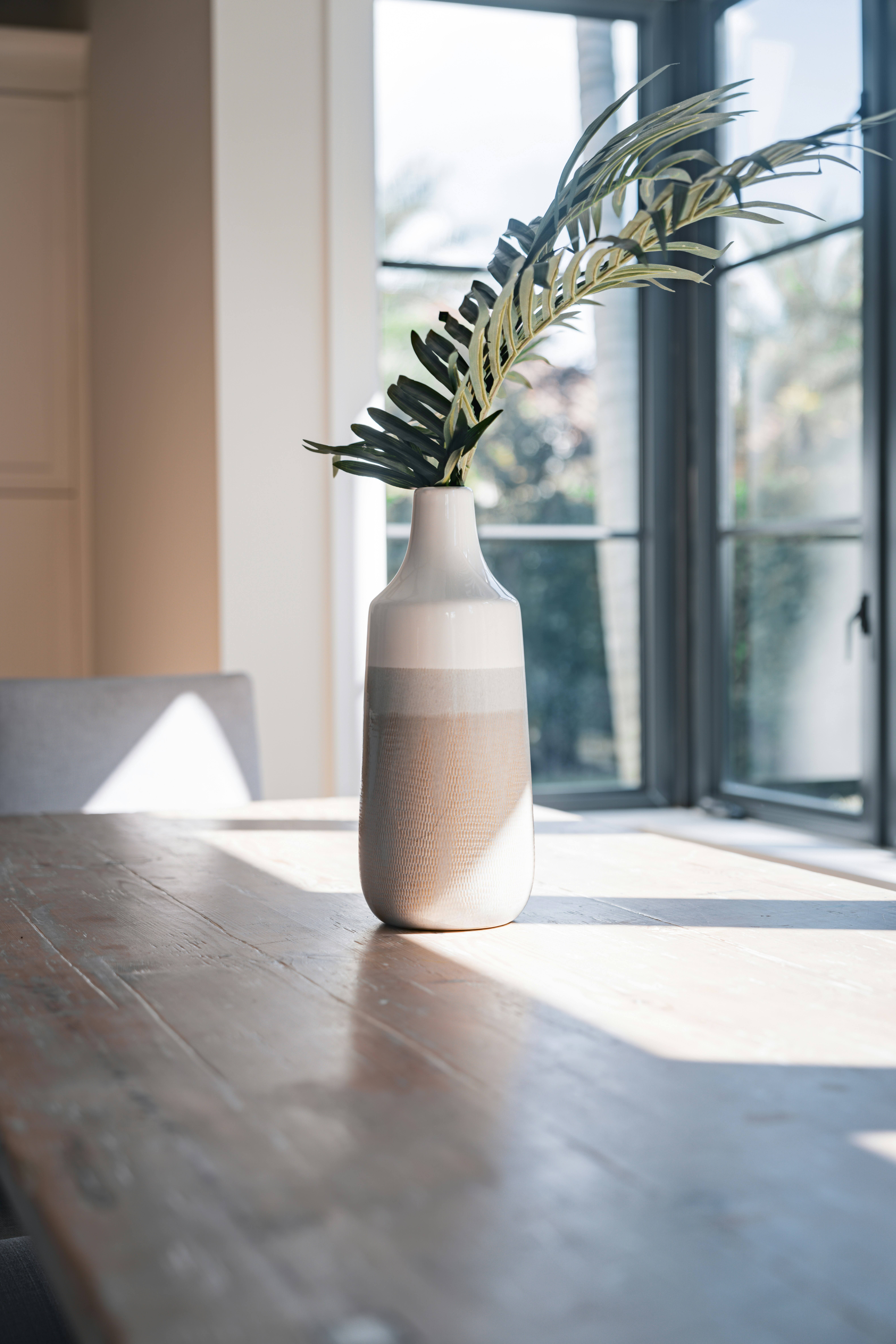 A vase with a plant in it sitting on a table