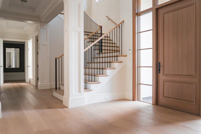A large room with a staircase and a wooden door