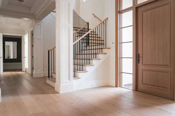 A large room with a staircase and a wooden door