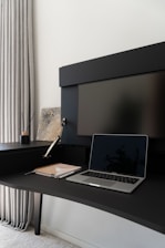 A laptop computer sitting on top of a black desk