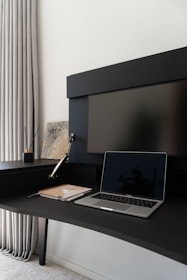 A laptop computer sitting on top of a black desk
