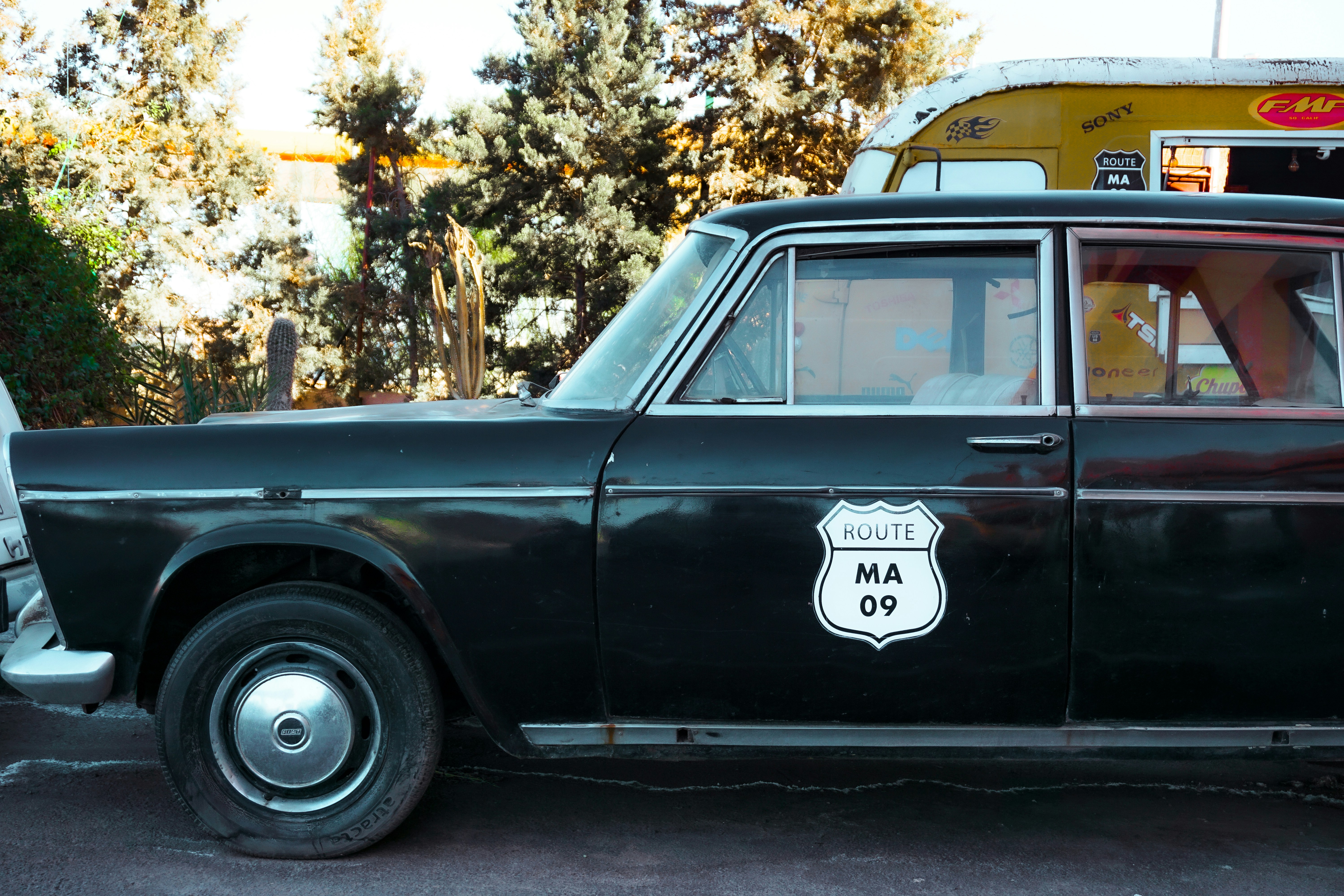 A man standing next to a black car in a parking lot