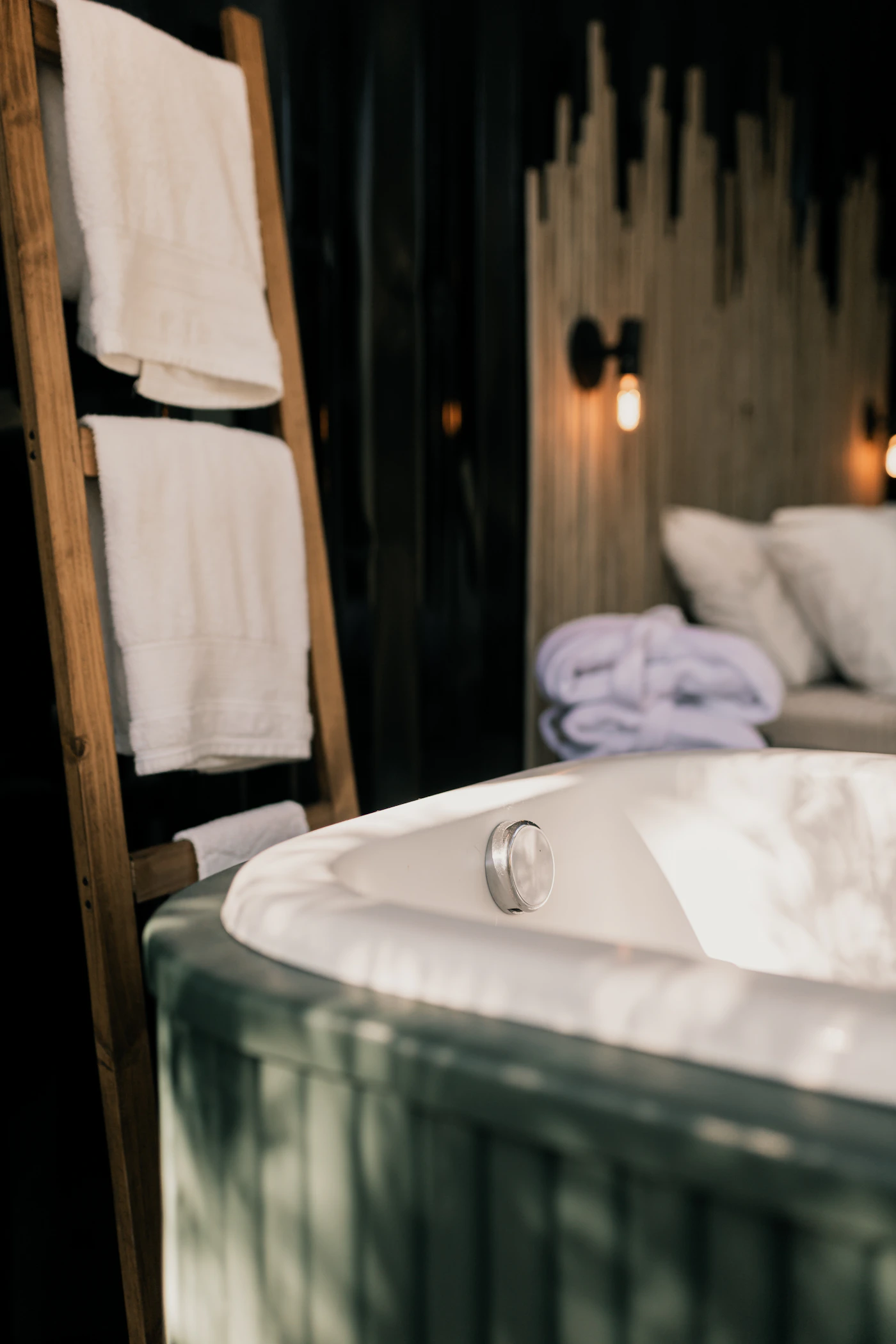 Wellness suite bathroom with a large private jacuzzi tub next to the bed