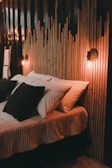 A bed with a wooden head board and pillows