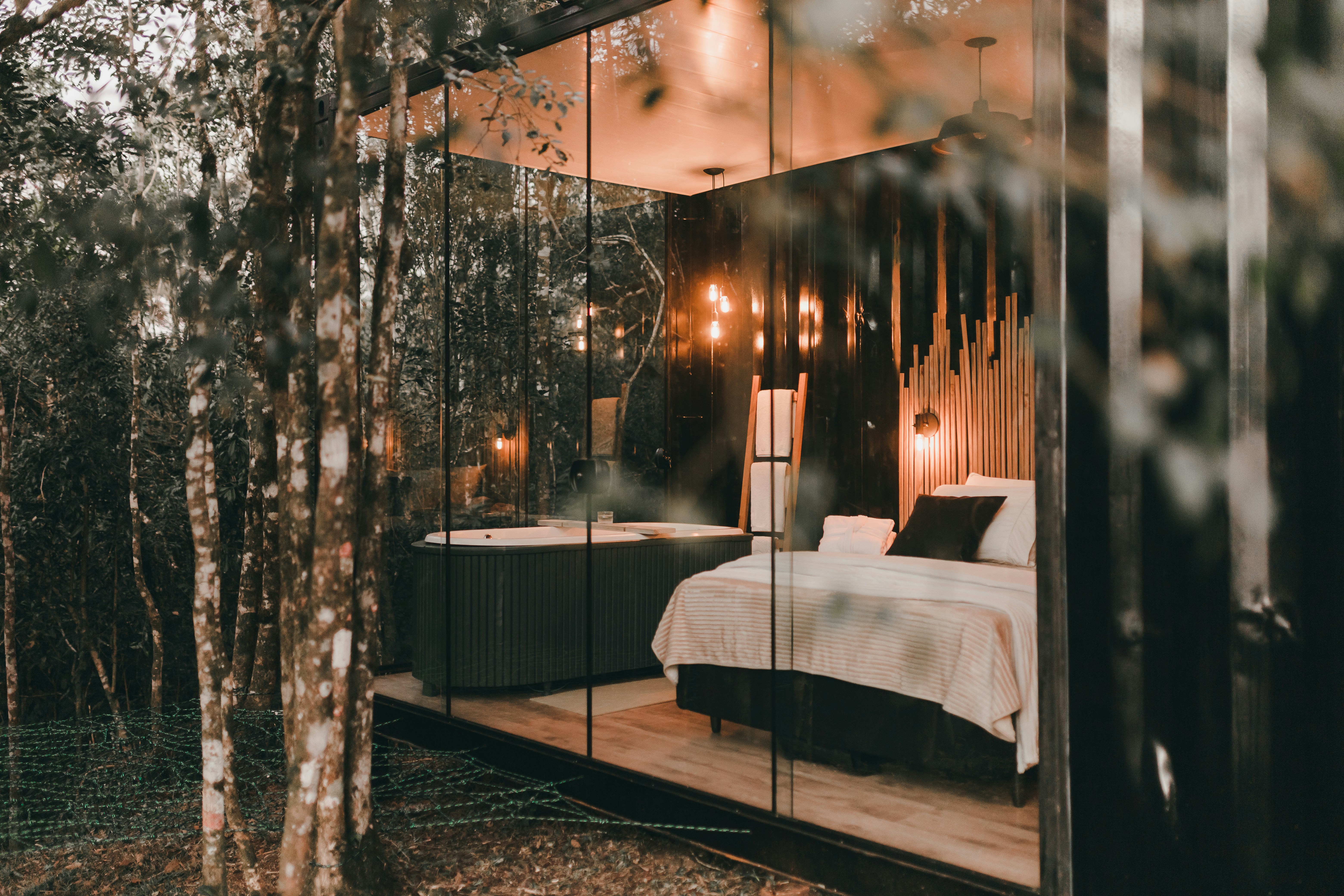 A bedroom is reflected in a mirrored wall, 