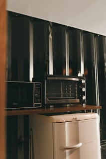 A microwave oven sitting on top of a refrigerator